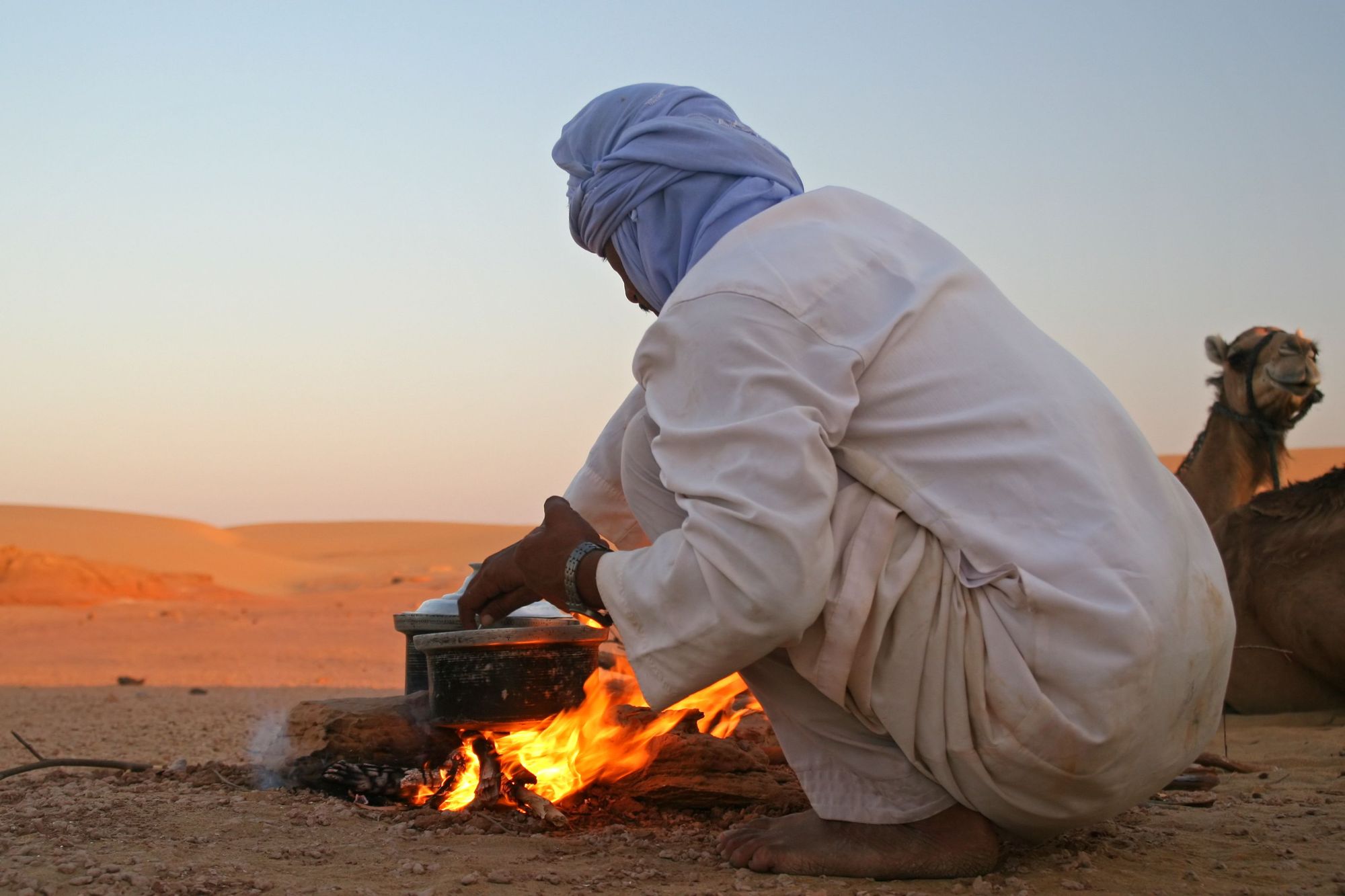 A Bedouin man cooks over an open fire in Wadi Rum desert, Jordan.