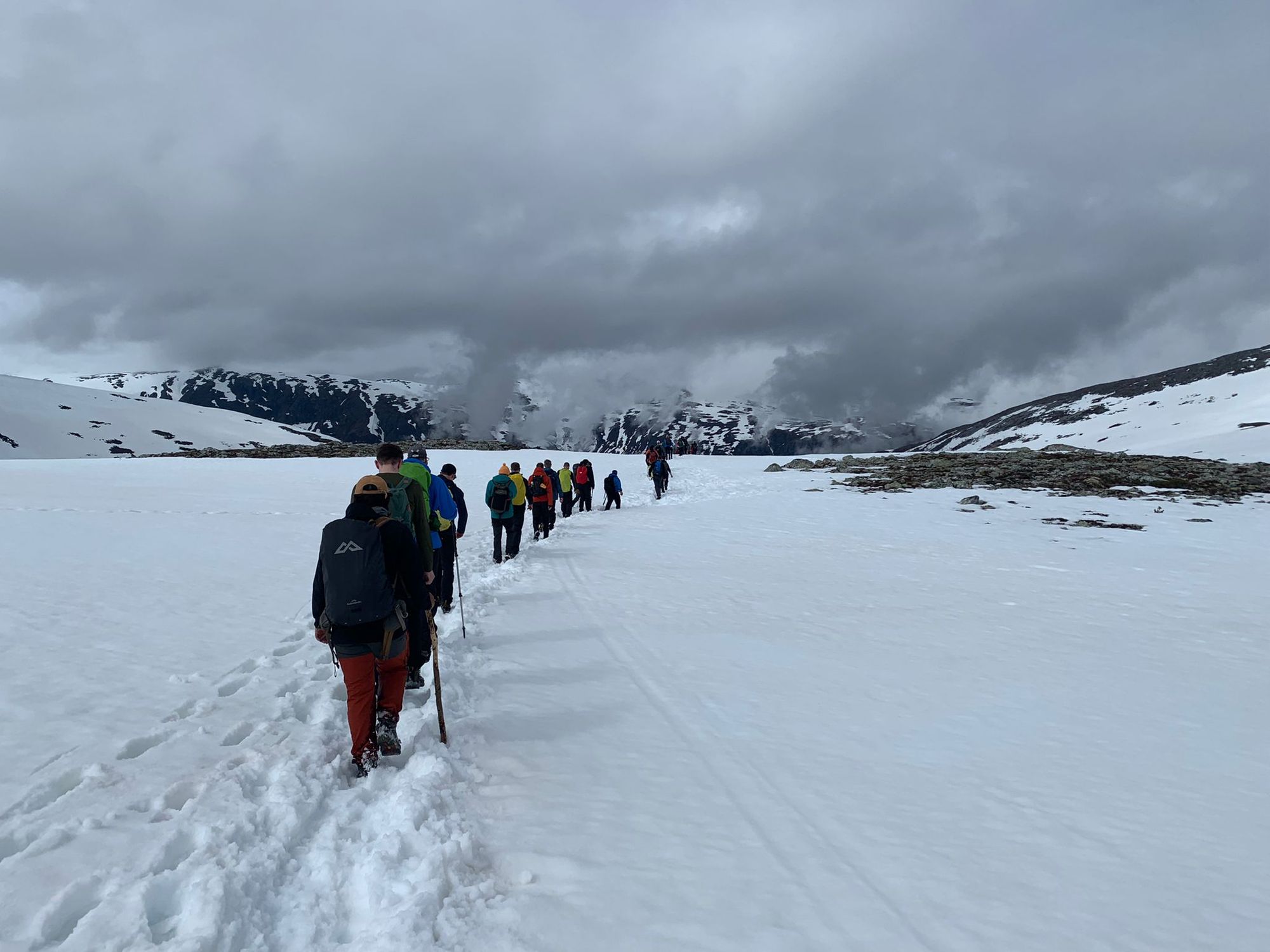 Hikers trudging through snow in the Norwegian fjords