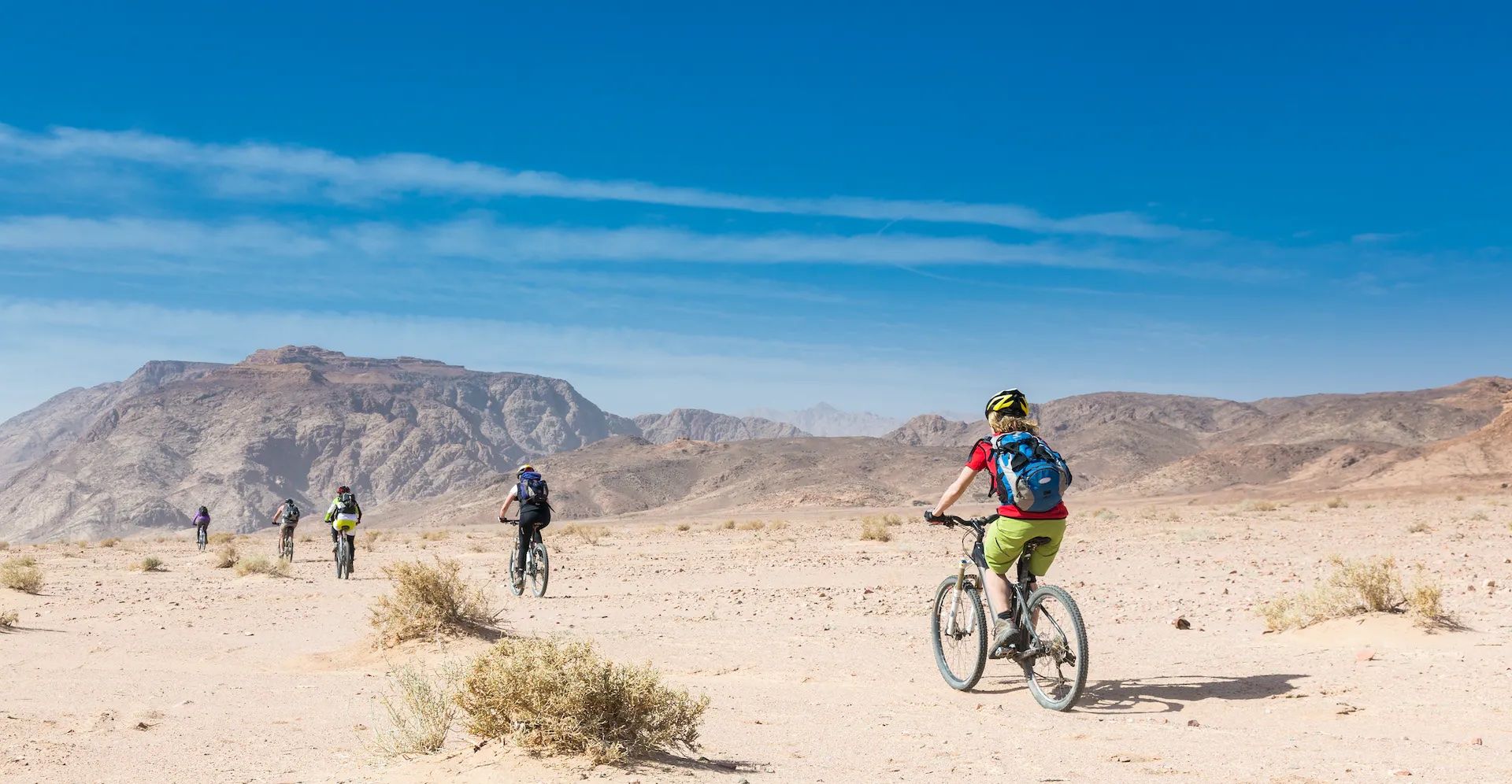 A group of cyclists riding through the desert in Jordan.