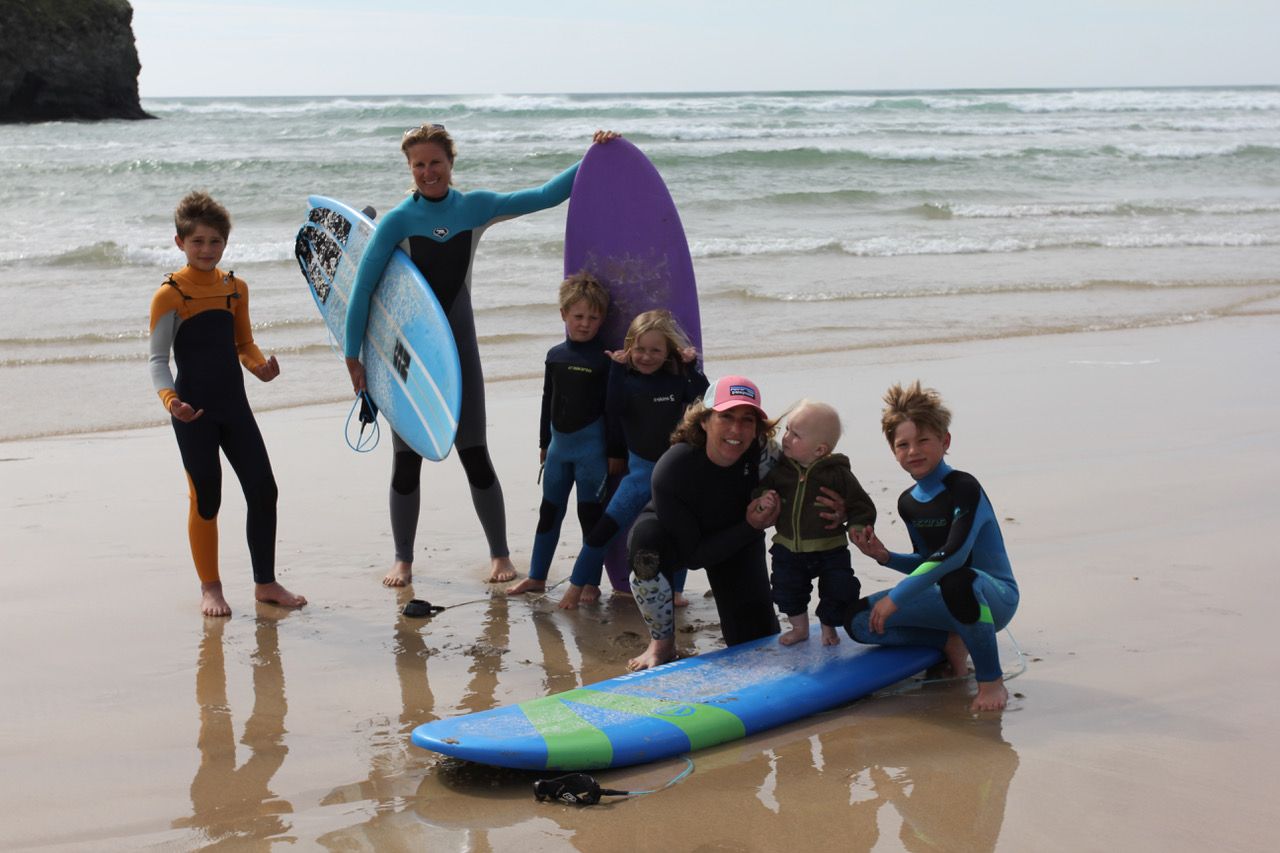 Two women surfers pose with their children.