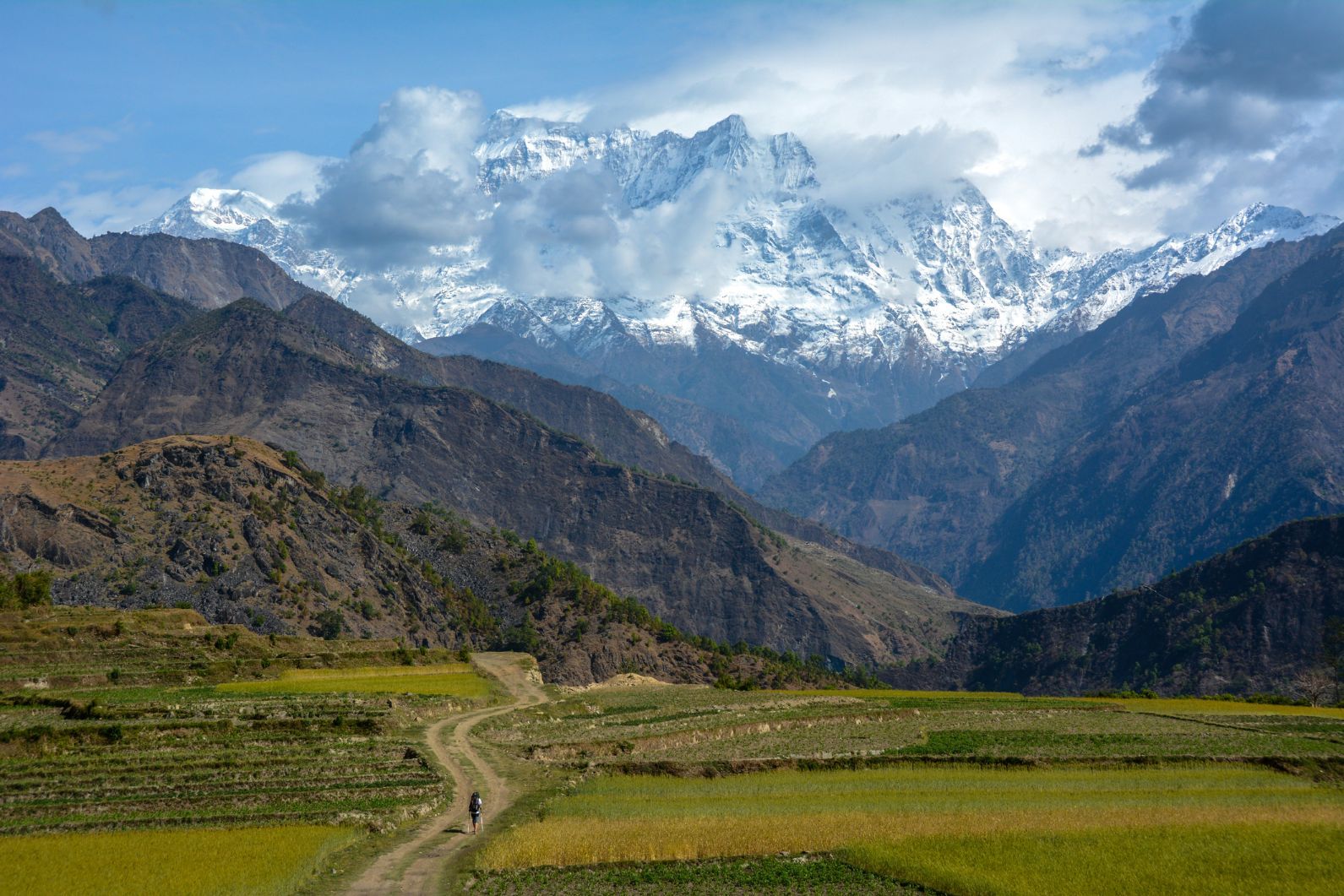 A solo hiker on the stunning Annapurna Circuit, with the big mountains up ahead. Photo: Getty