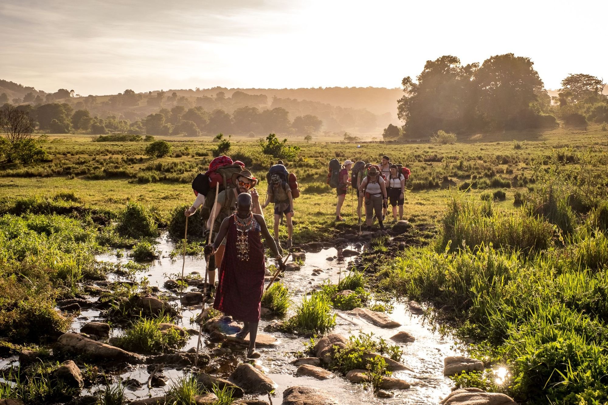 A group being led over the plains of the Loita Hills by a Maasai Guide, adorned in beadwork. Photo: Much Better Adventures.