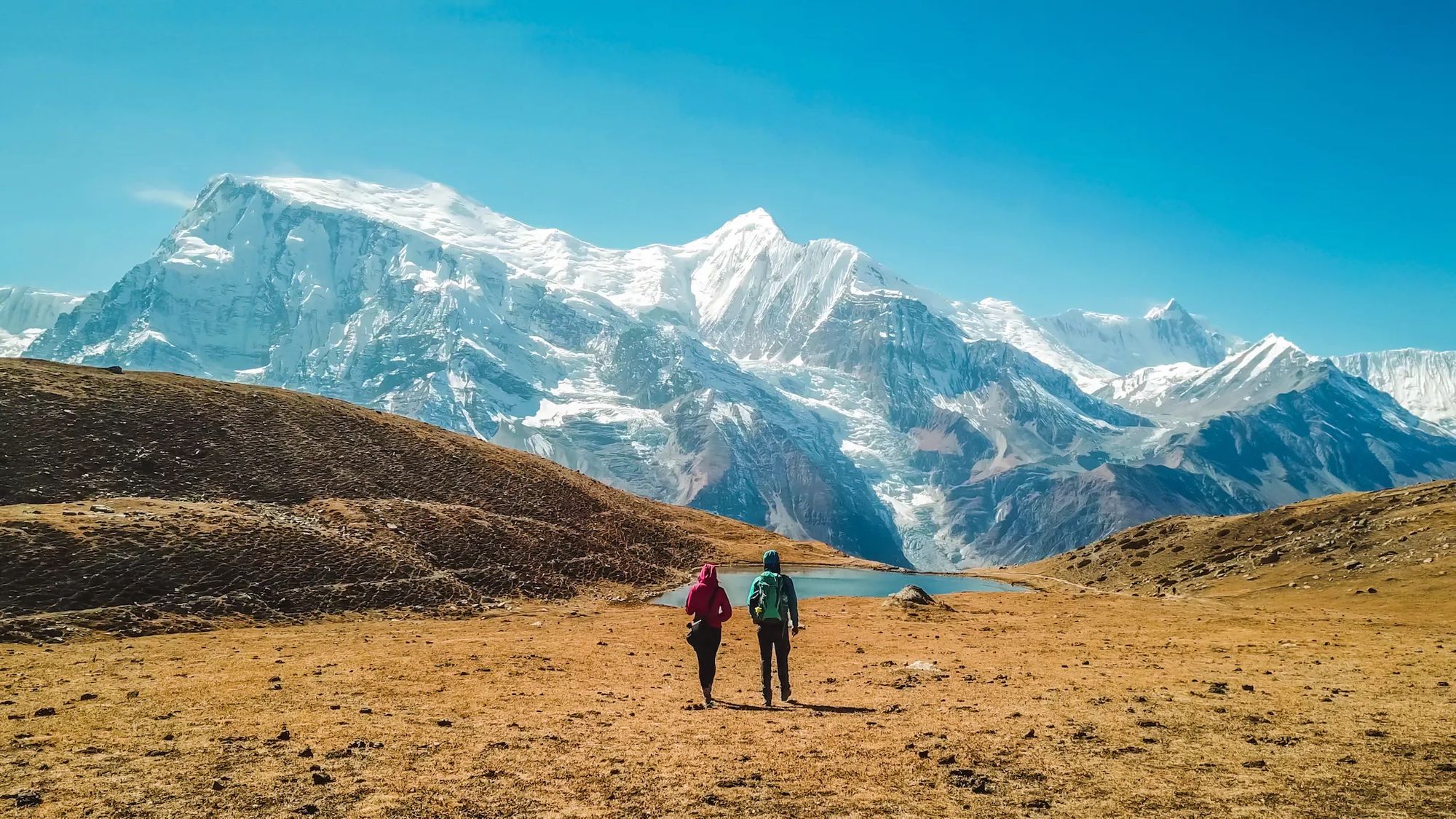 Two hikers stare out at the Annapurna massif in Nepal.