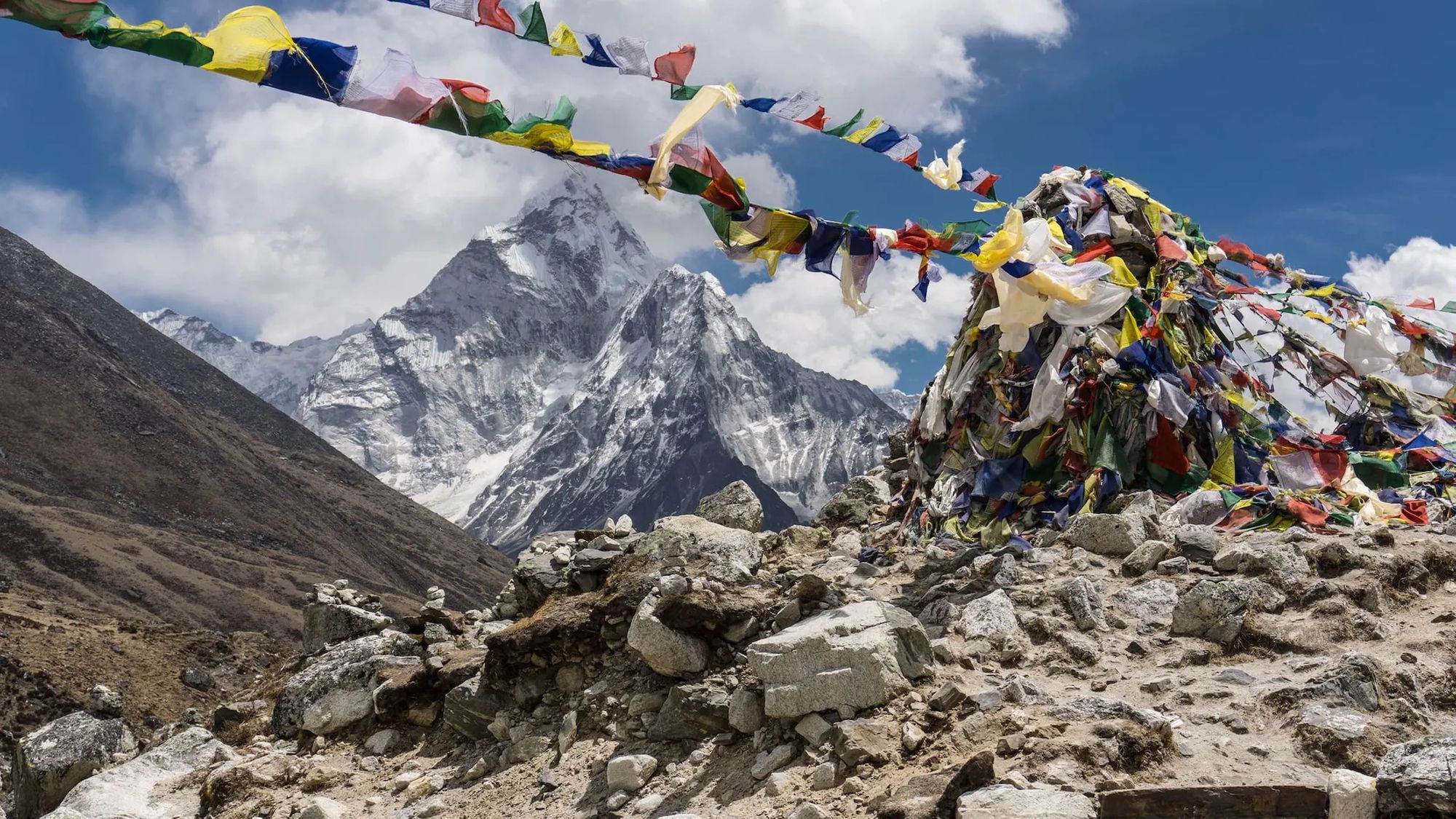 A view of Mount Everest with prayer flags in the foreground.