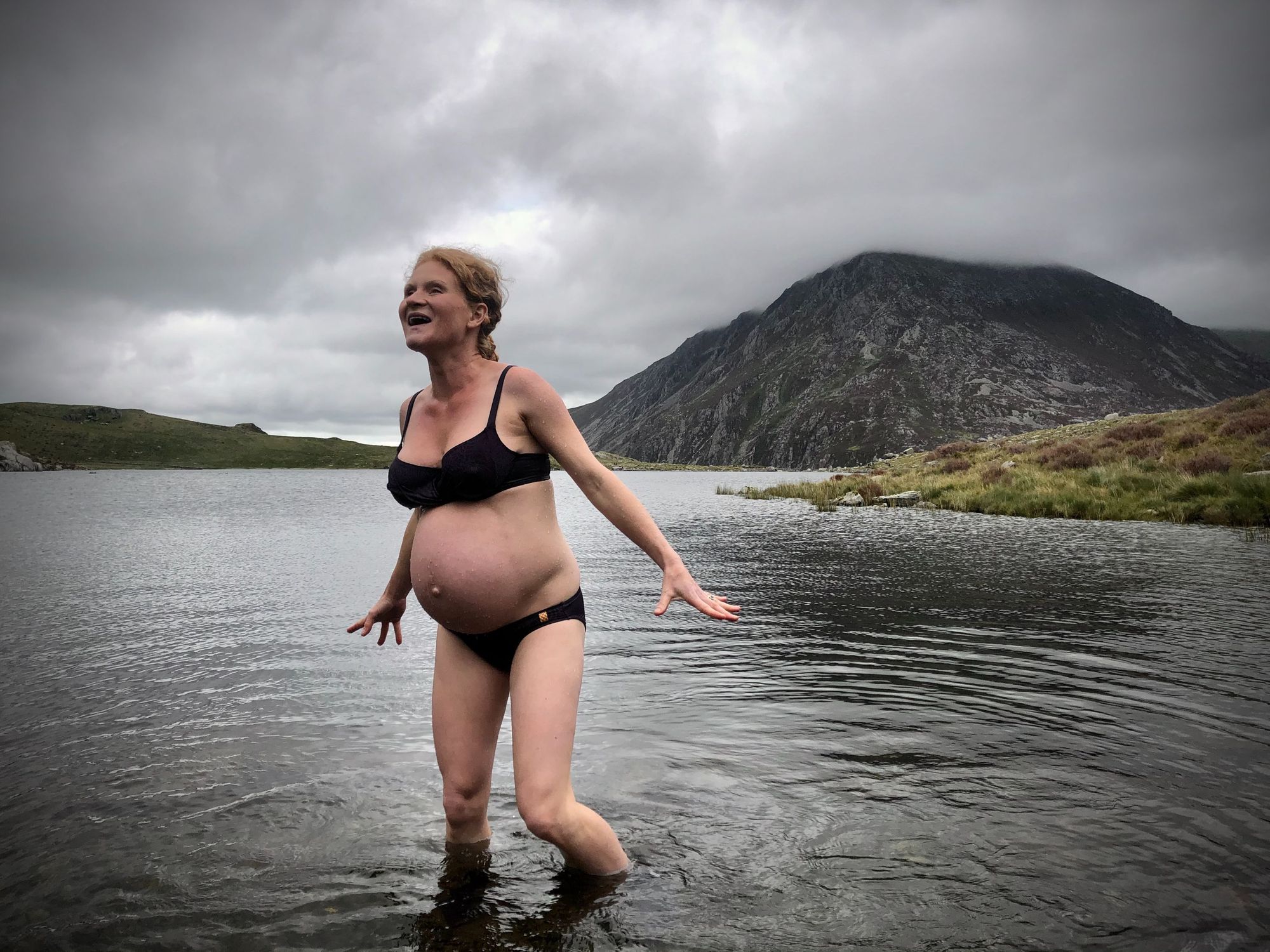 A pregnant woman in a mountain lake.