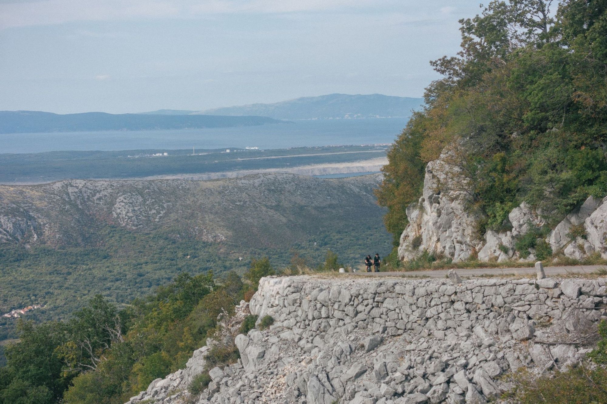 Two of the Restrap team make their way up an exposed mountain road in Croatia, with the Adriatic Sea behind. Photo: Restrap