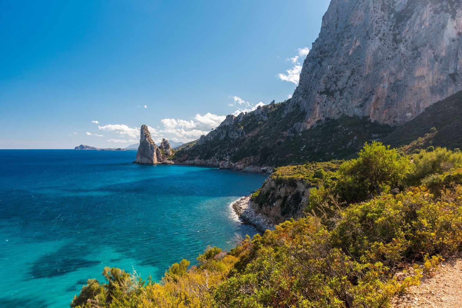 The Sardinian coastline near Santa Maria Navarrese, with the rock pinnacle of Pedra Longa in the background. Photo: Getty