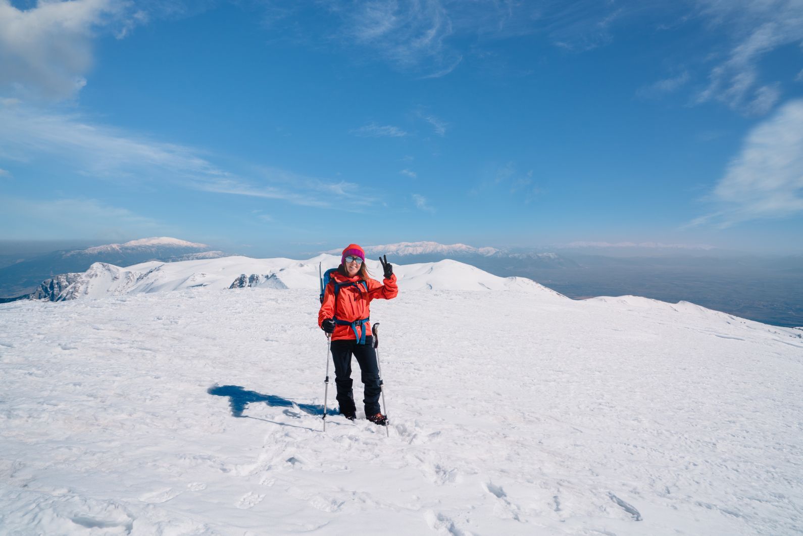 An adventurer throws up a peace sign after reaching the top of a mountain plateau. Photo: Getty