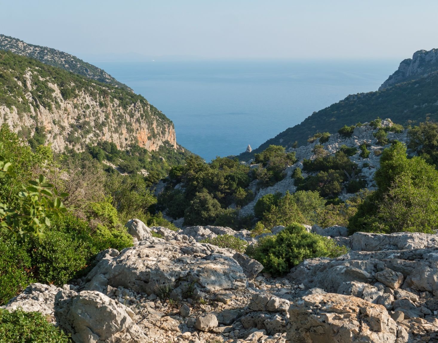 A view of a rocky, green valley with a hiking path to Cala Goloritze beach in Sardinia. Photo: Getty
