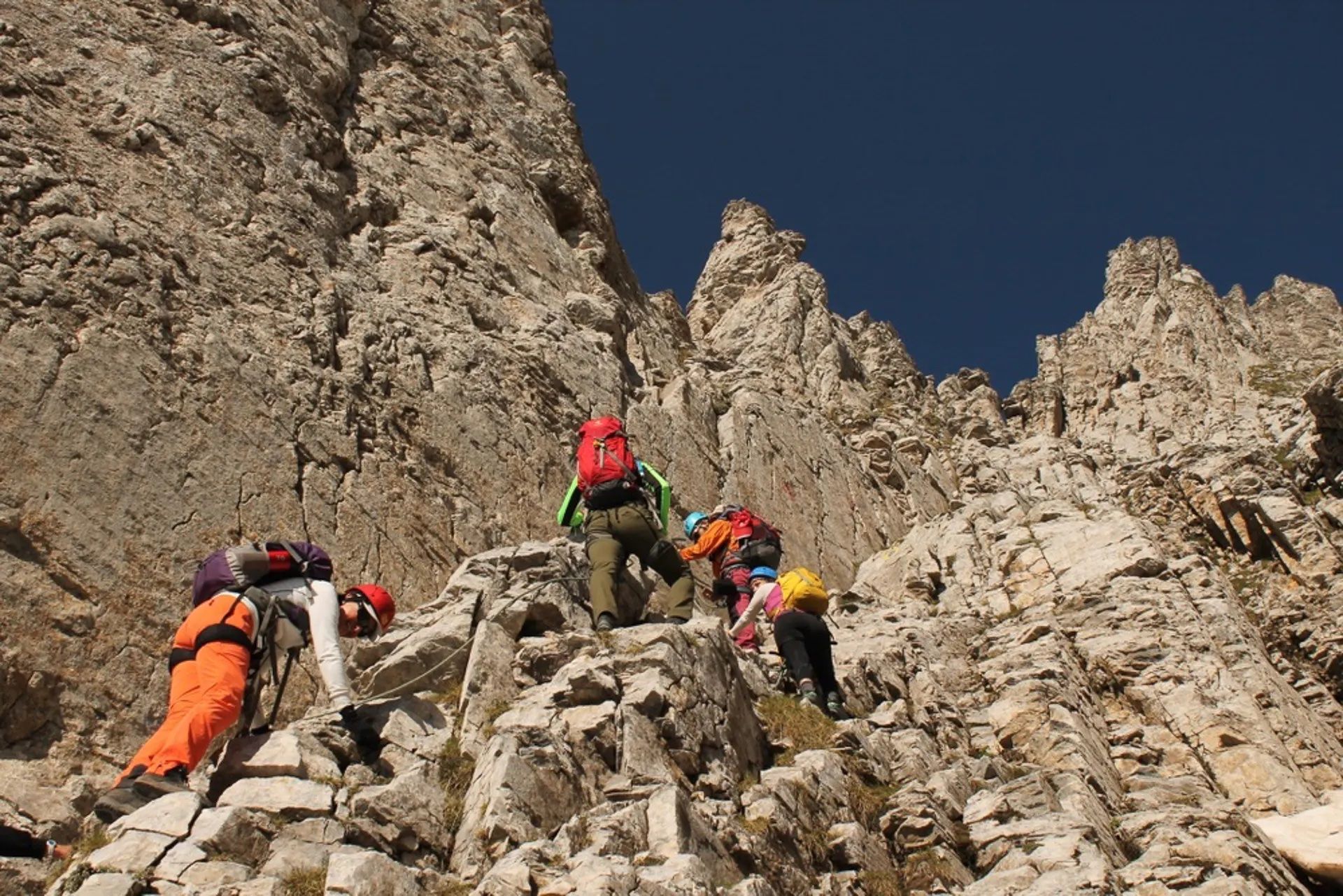 Hikers scrambling up to the peak of Mount Olympus.