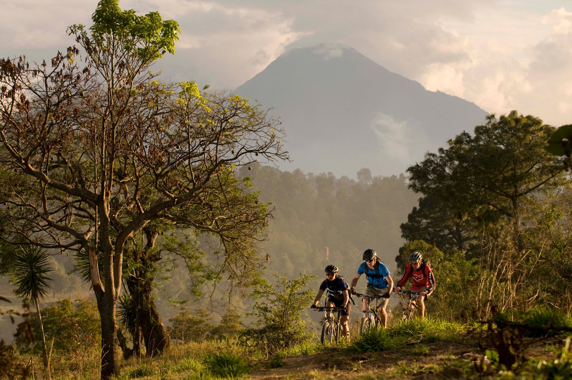 Cyclists pedalling with a volcano backdrop in Guatemala