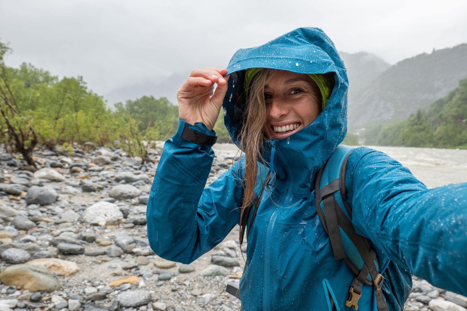 A female hiker takes a selfie during a rain shower