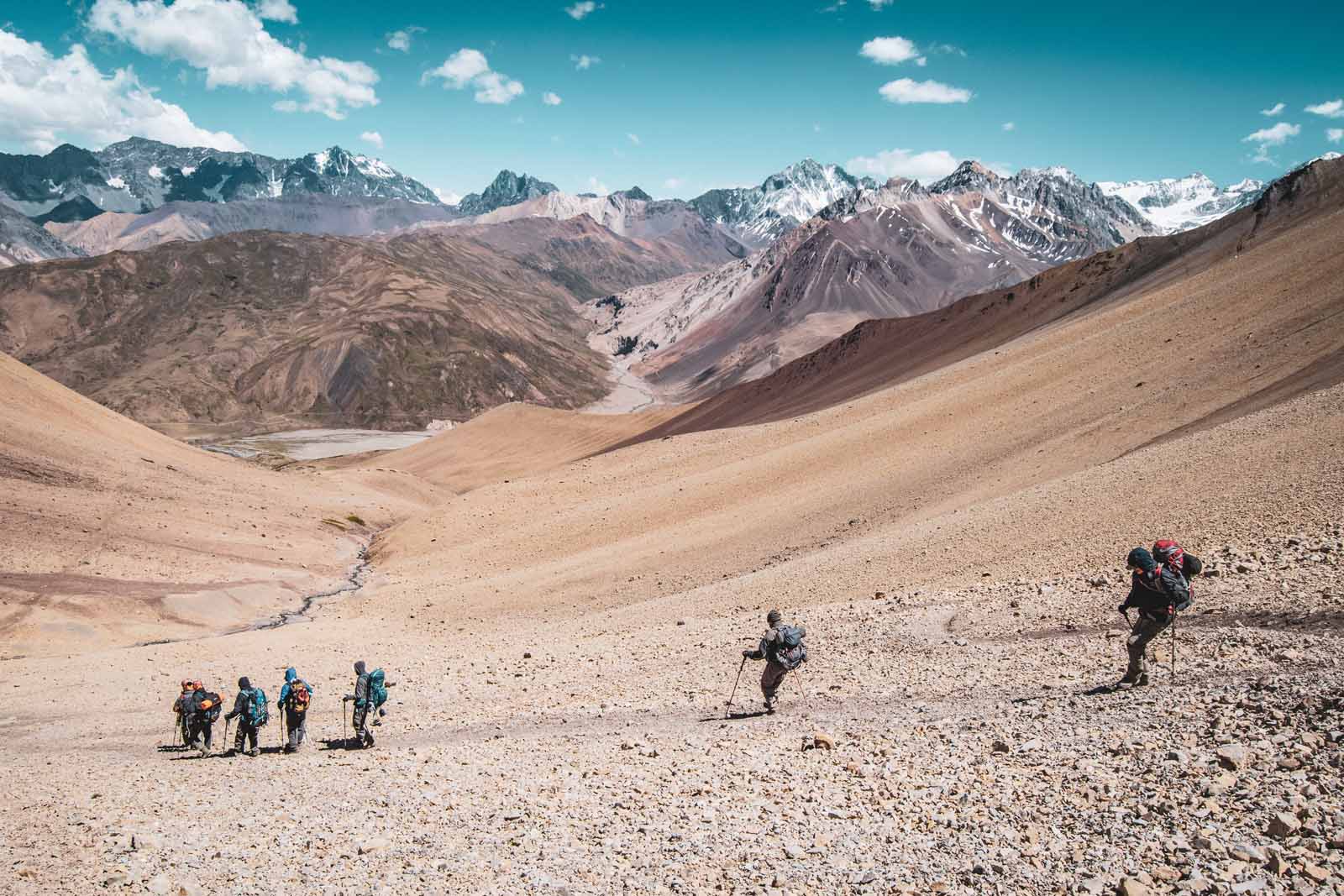 Hikers make their way down the Piuquenes Pass in the Andes