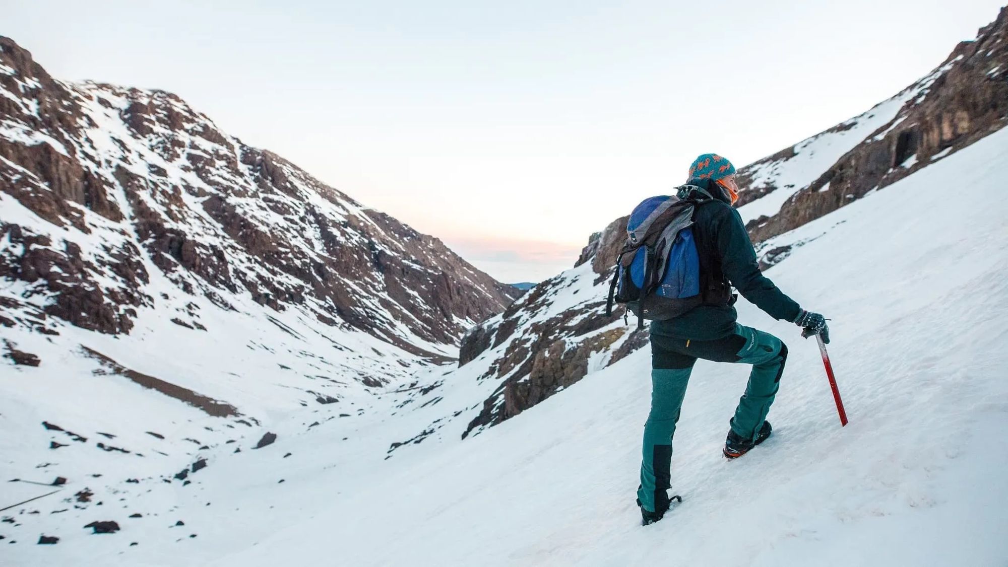 A hiker climbing up Mount Toubkal in the winter.