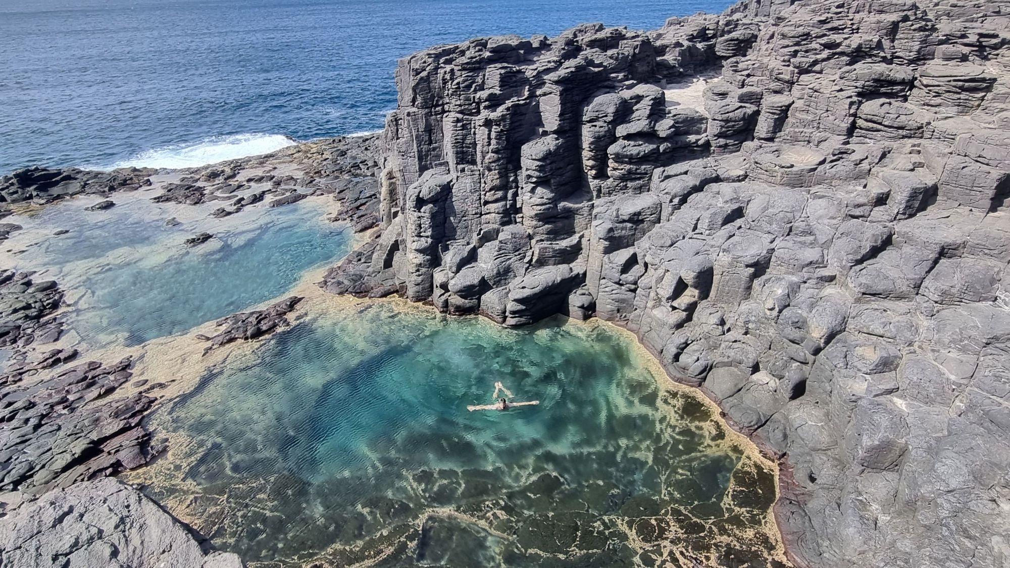 A swimmer floats in the beautiful Cuba Natural Pool, Cape Verde