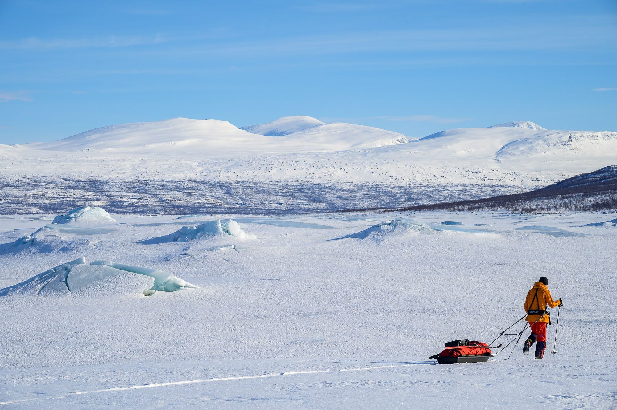 A man drags a sledge across the frozen Lake Baikal.