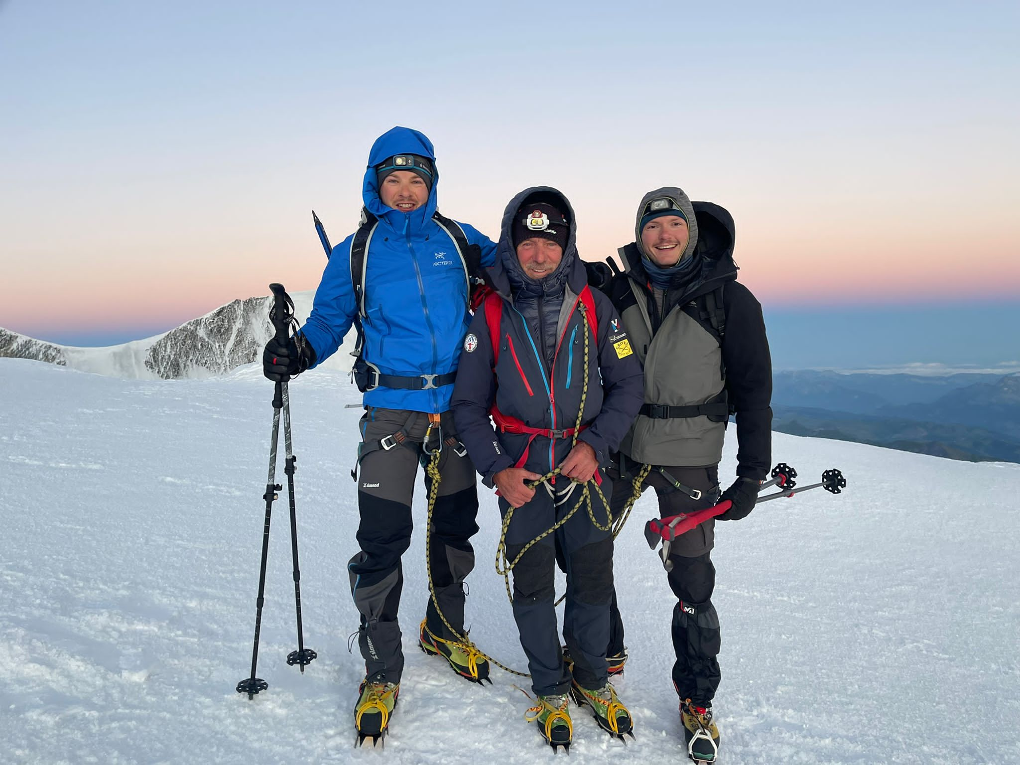 Three climbers pose at the top of Mont Blanc.