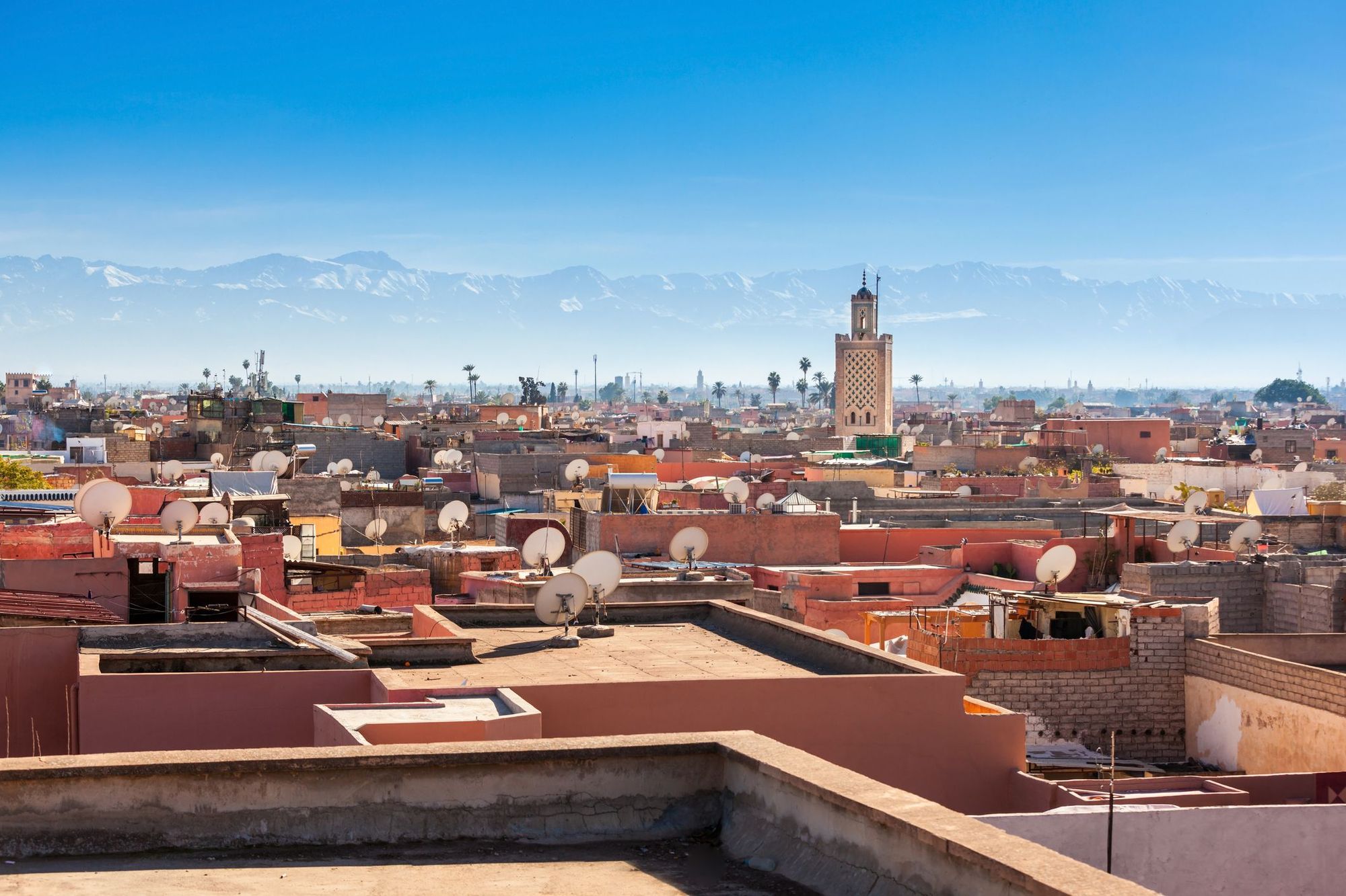 An aerial view of Marrakech, with the Atlas Mountains in the background, taken from a roof terrace.