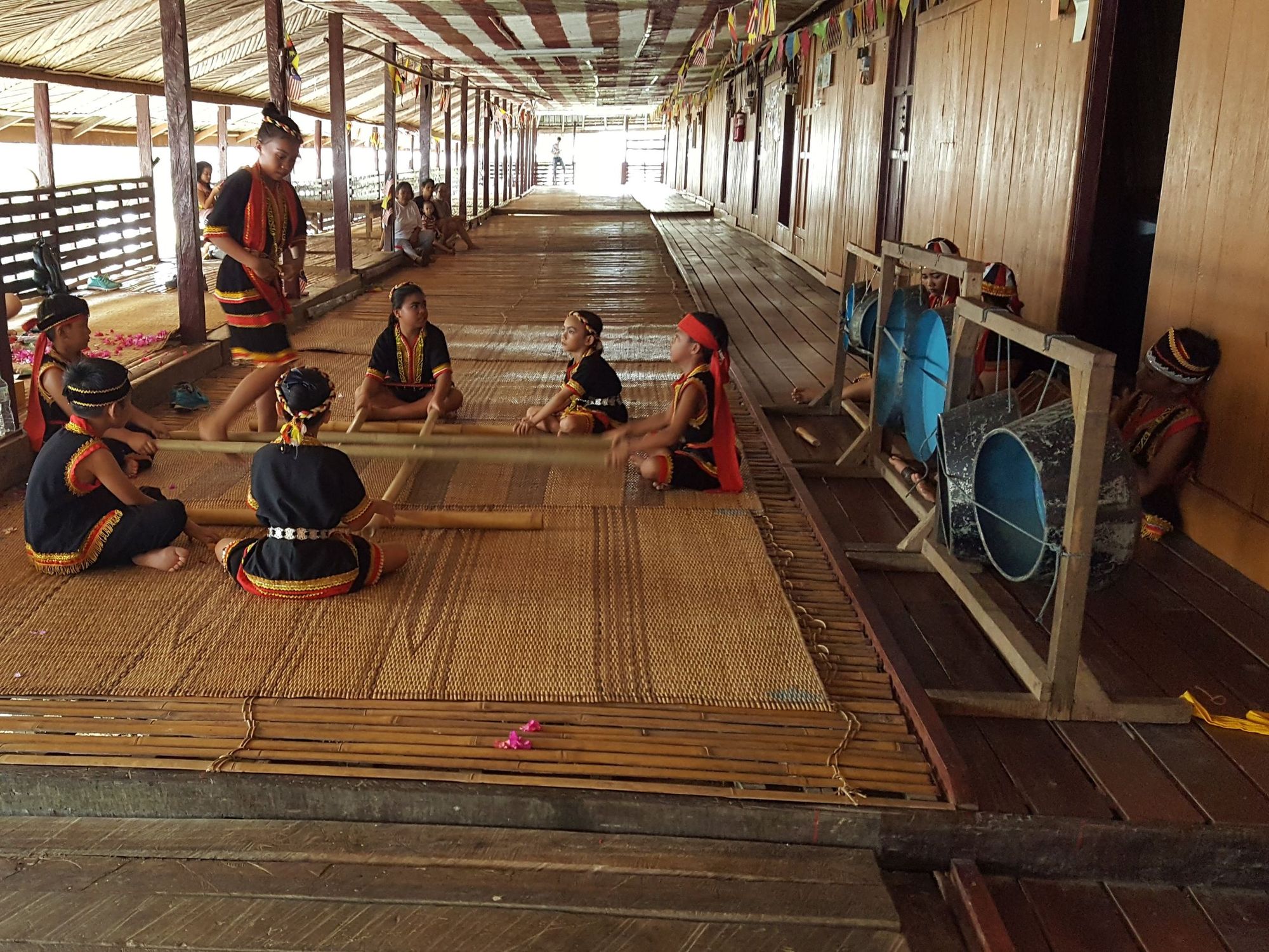 Indigenous Dayak people relaxing under the roof of a typical longhouse. Photo: Paradeso Borneo