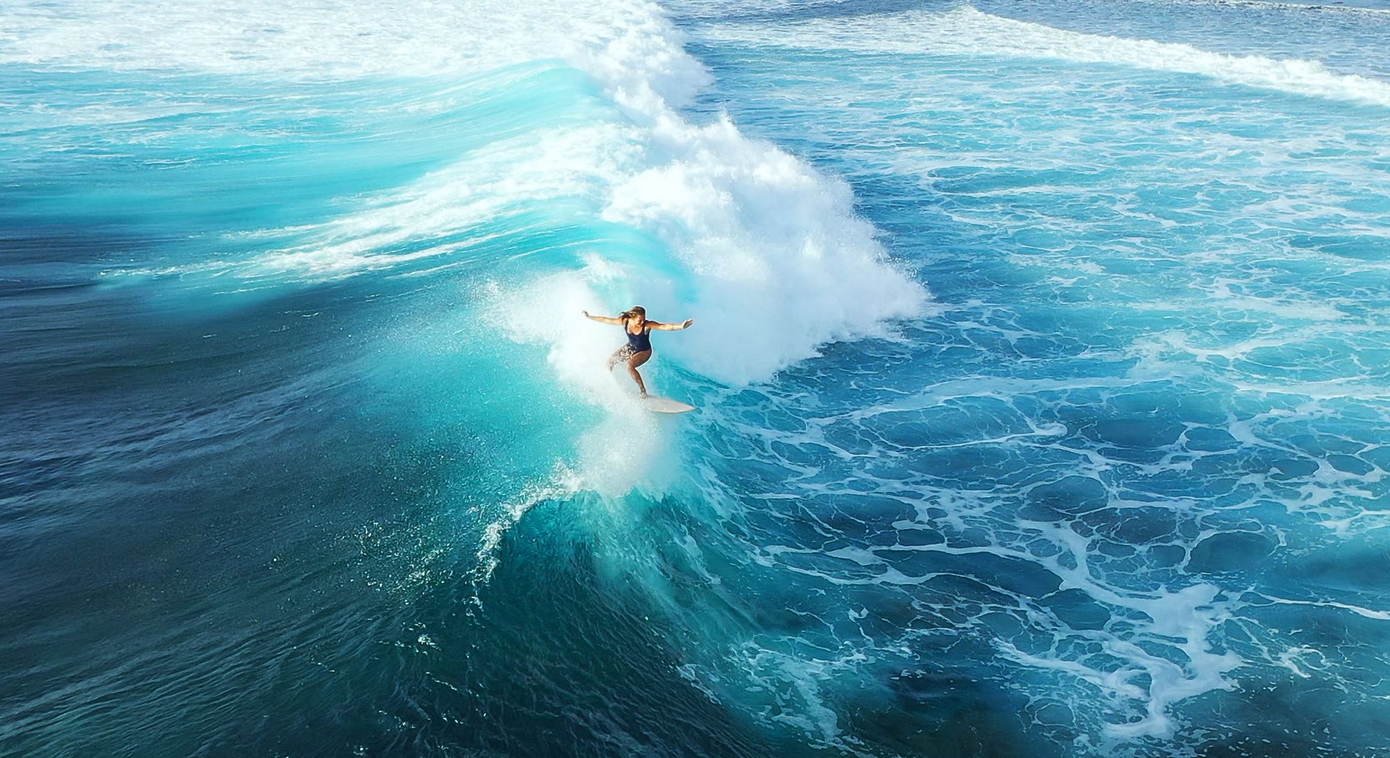 A woman surfs a wave