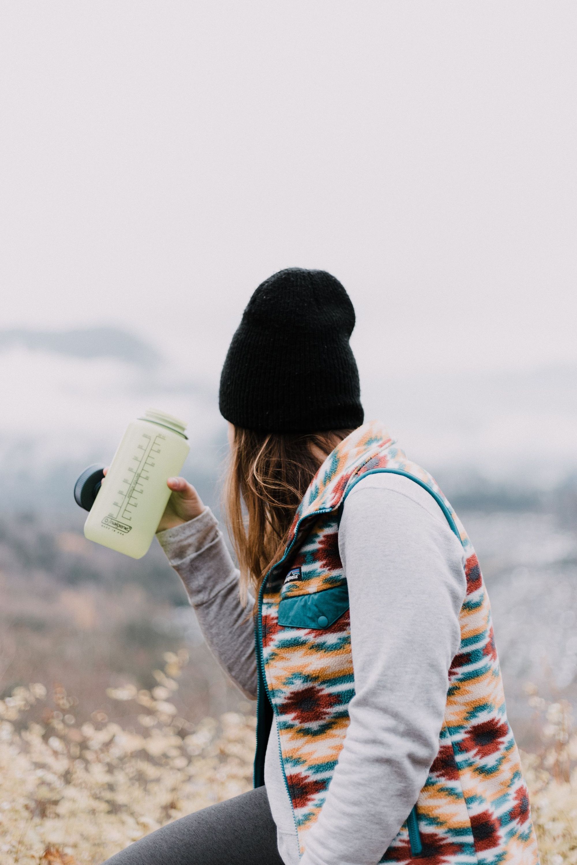 A woman takes a drink out of a Nalgene water bottle. Photo: Priscilla Du Preez on Unsplash.