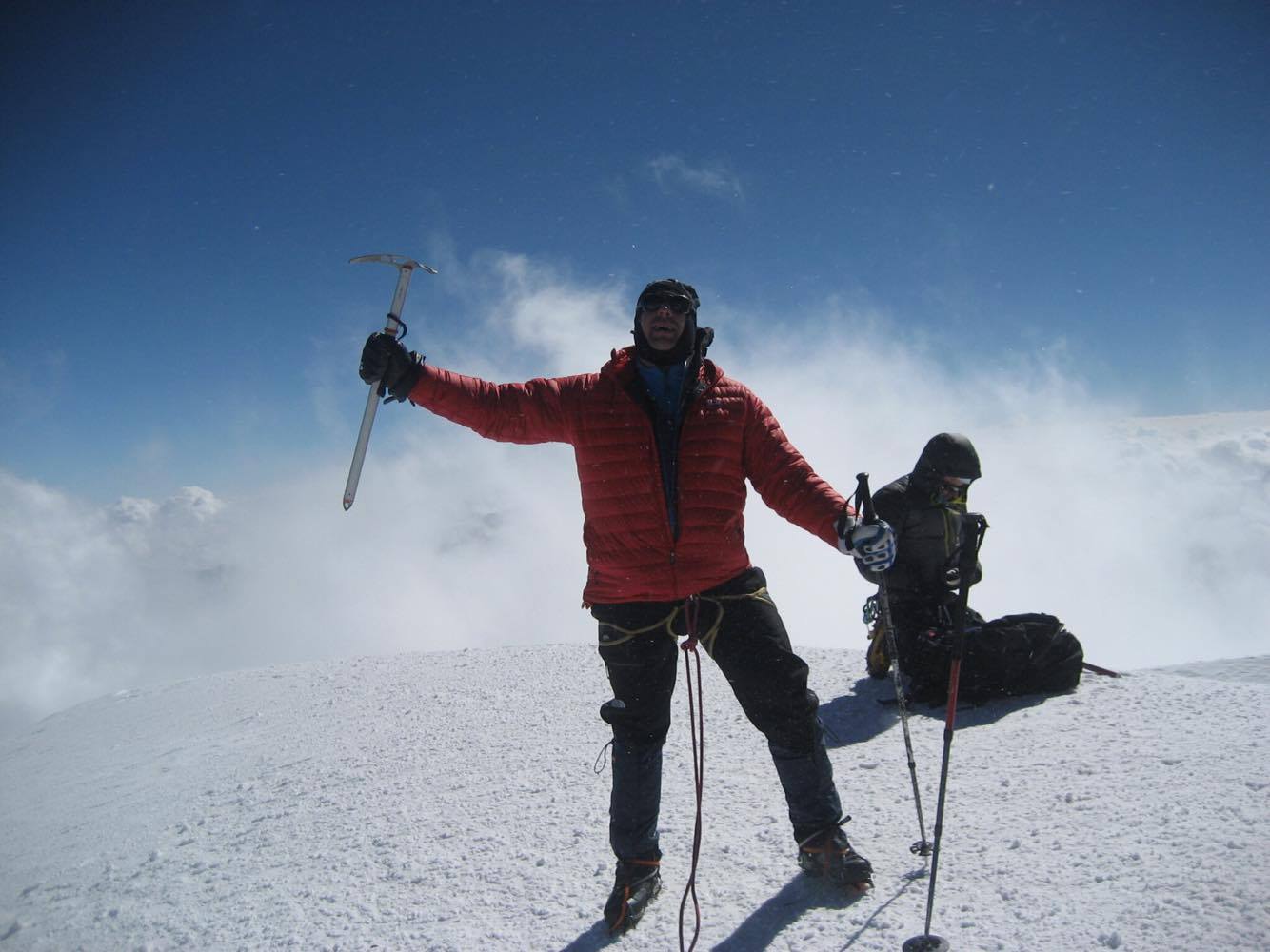 A climber celebrates on the summit of Mount Kazbek.