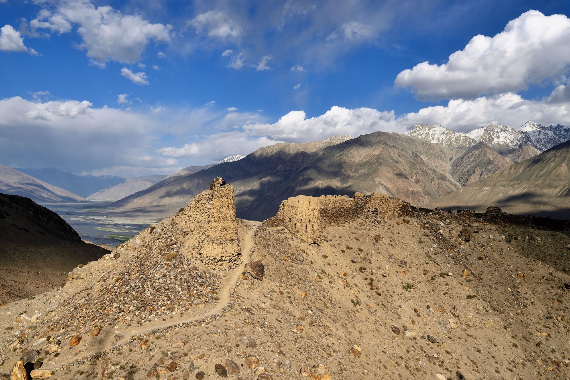 The ruins of the Yamchun Fort and the white Hindu Kush range in Afghanistan, Tajikistan, Central Asia