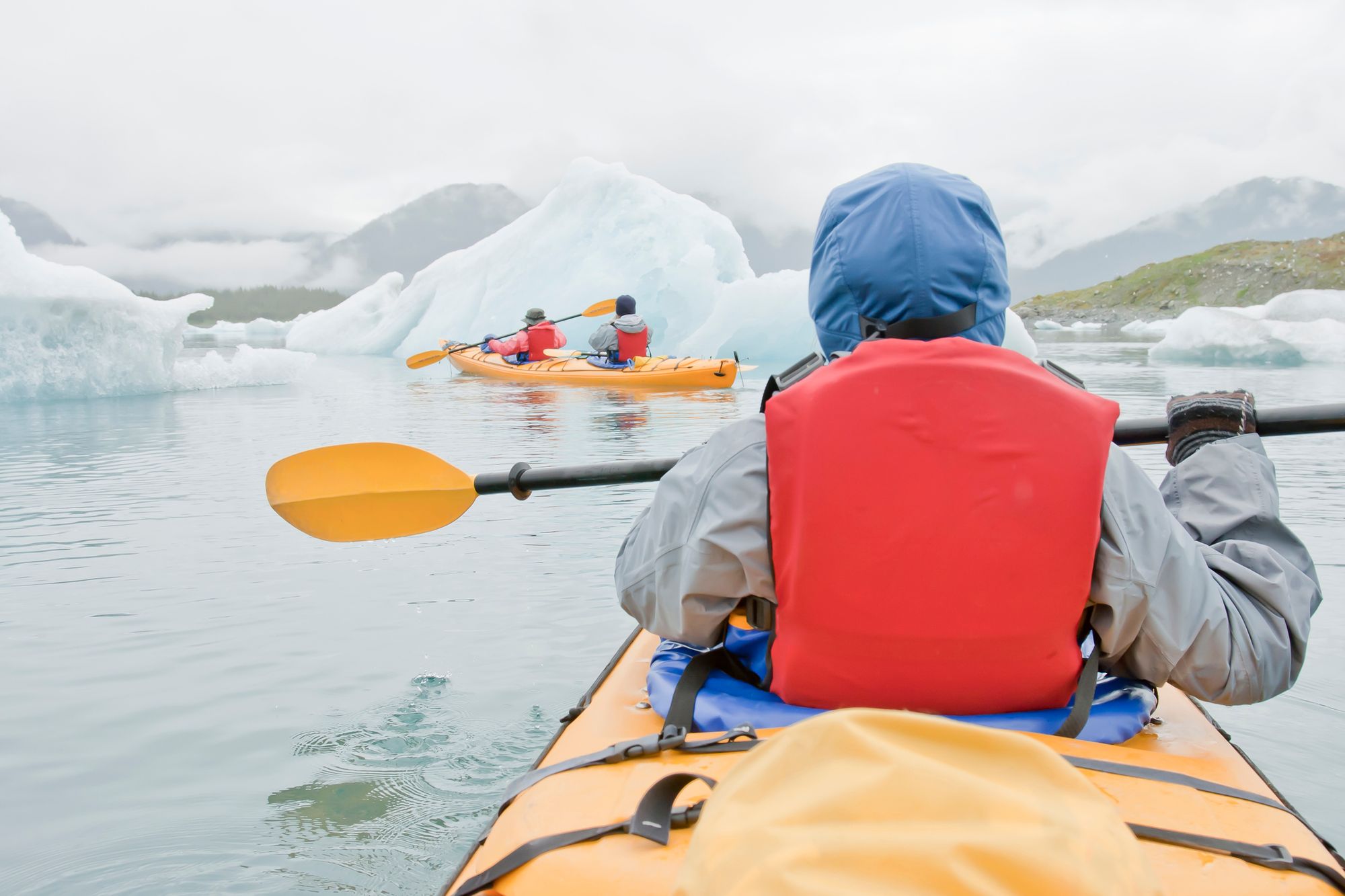 Three kayakers in Alaska. 