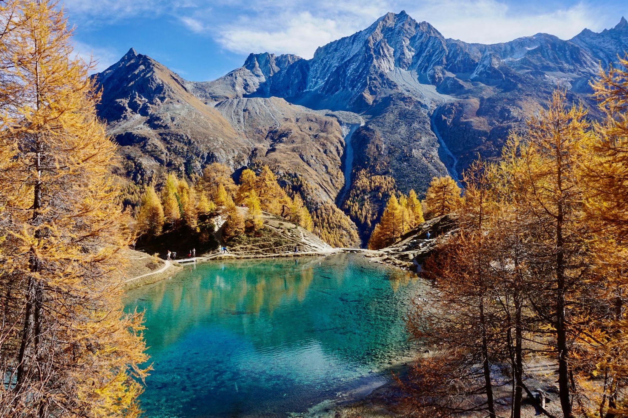 A panorama of Lac Bleu of Arolla lake in Canton Valais in the colourful autumn season with reflection of Dent de Veisivi and Dent di Perroc peaks. Photo: Getty