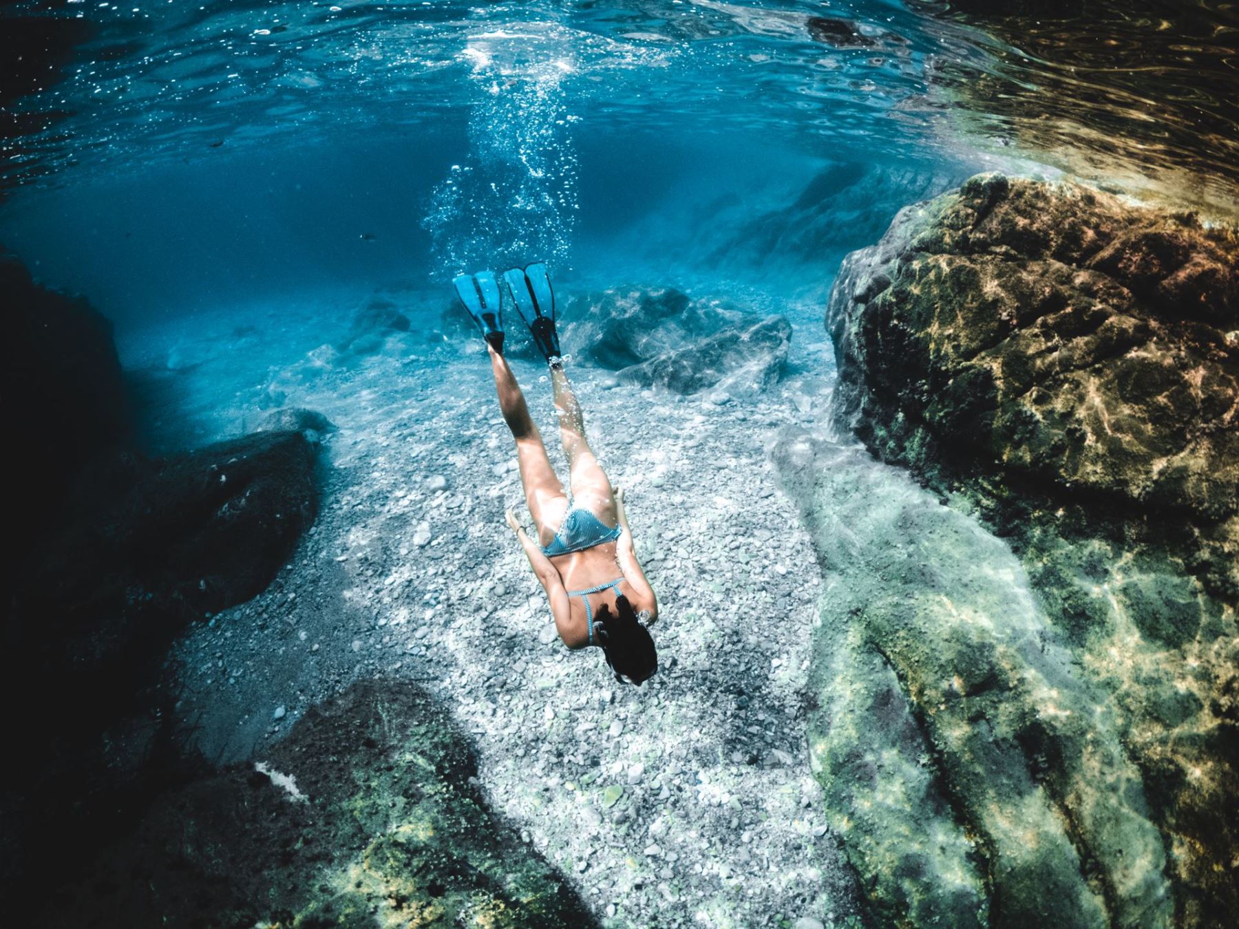 A woman snorkelling in the seas, near the Italian island of Elba