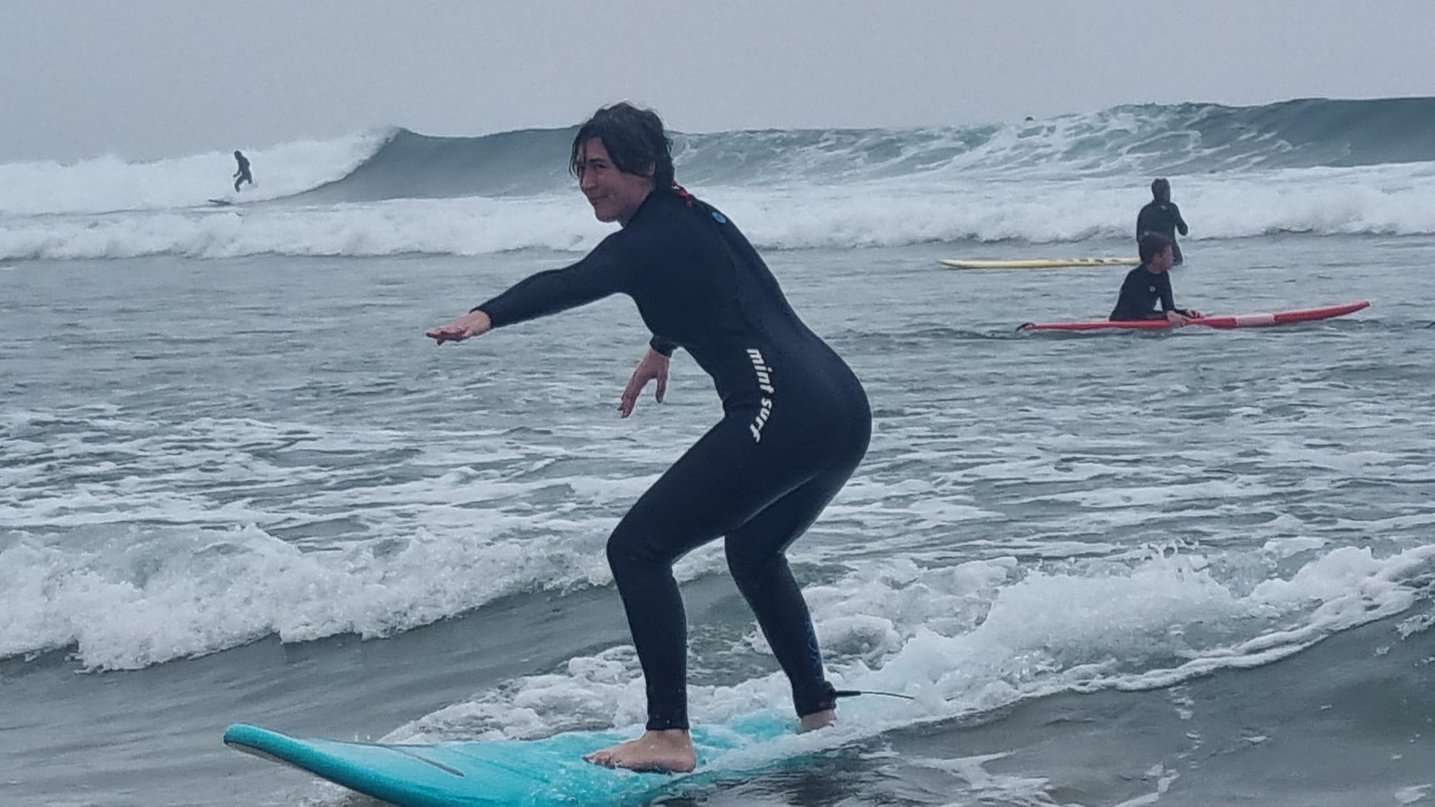 A female surfer surfs a wave in Taghazout, Morocco.