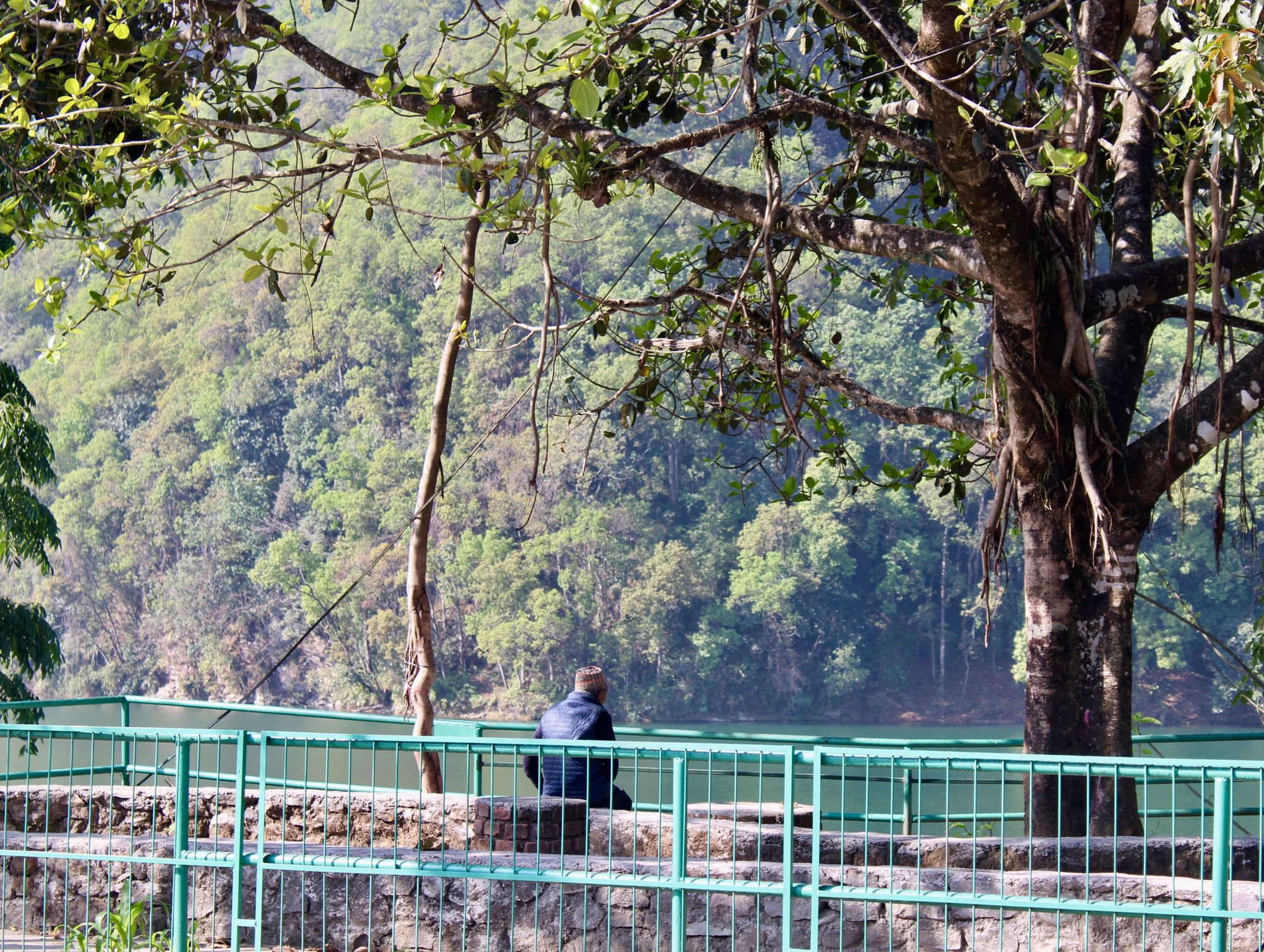 A contemplative man sat by Phewa Lake, Pokhara, Nepal.