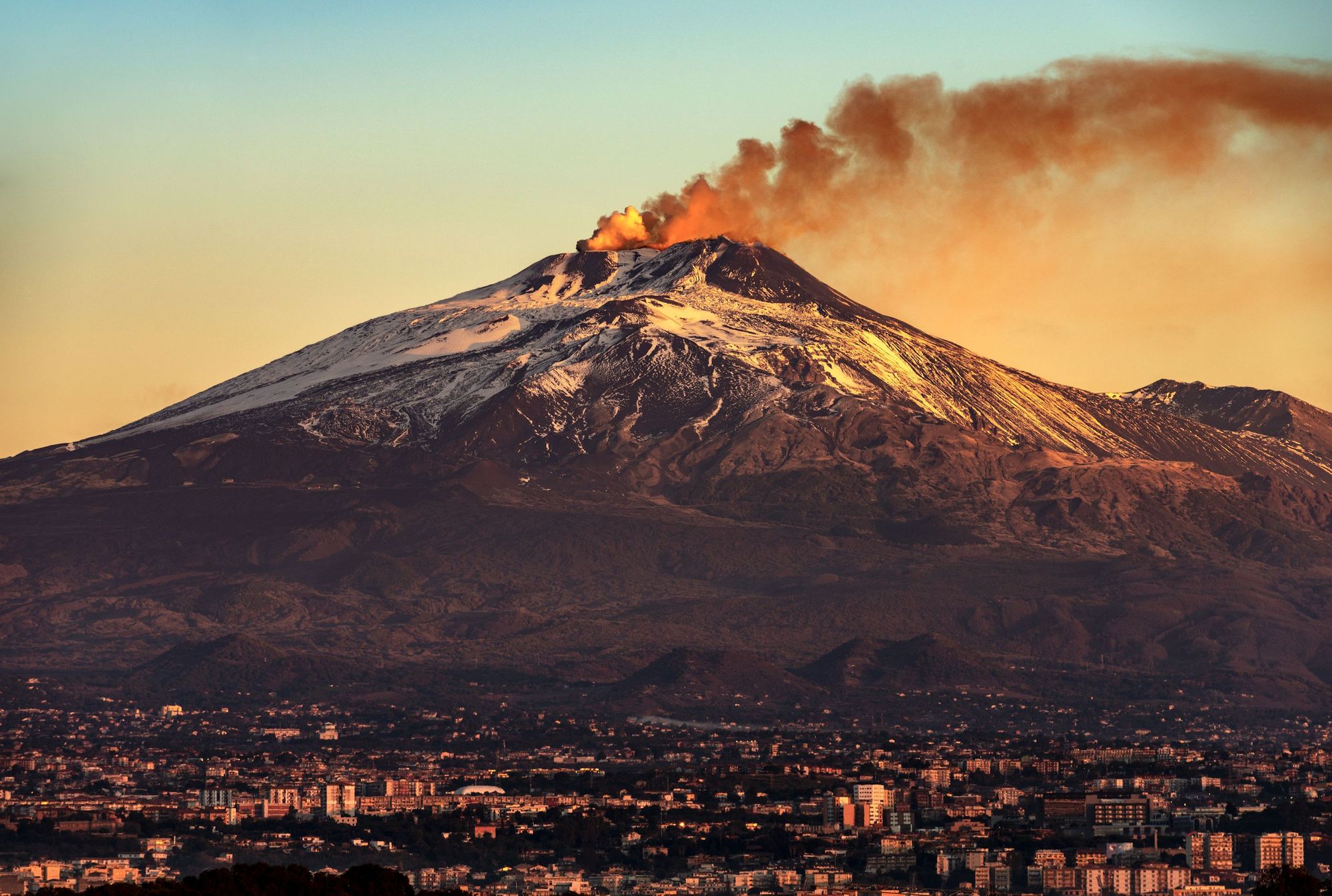 The towering lump of Mount Etna, the highest mountain on Sicily, toweing over the city of Catania. Photo: Getty