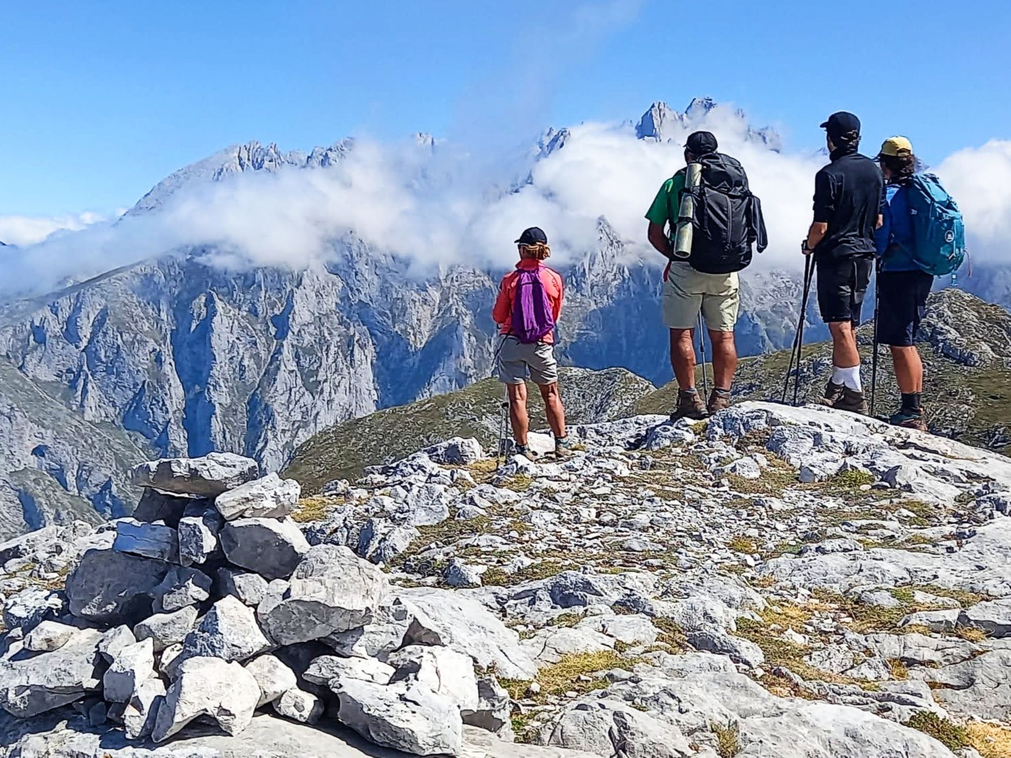 Four hikers looking out over the Picos de Europa in Spain