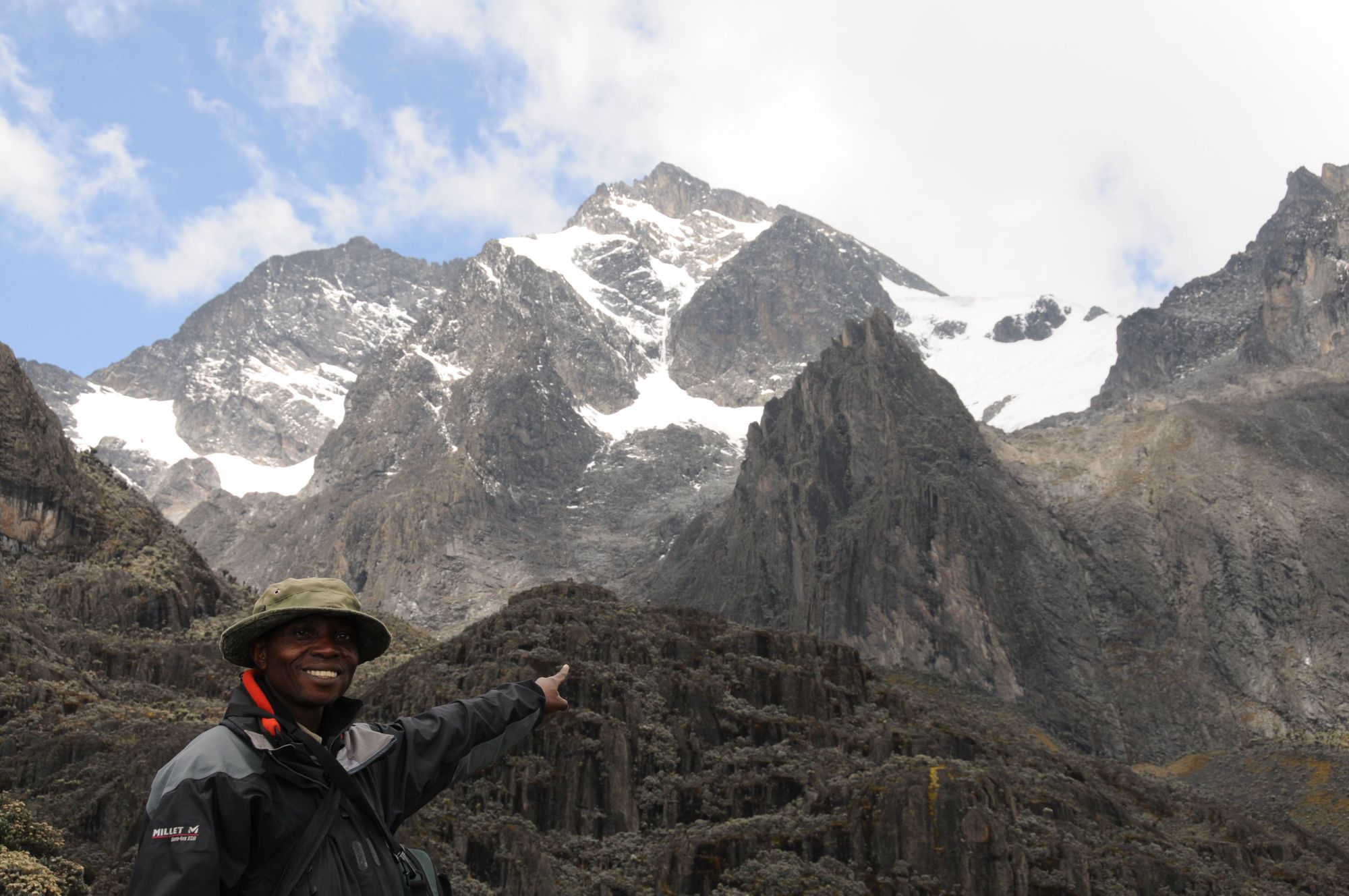 A guide gestures up towards the Rwenzori Mountains from the Virunga National Park. Photo: Wikimedia Commons