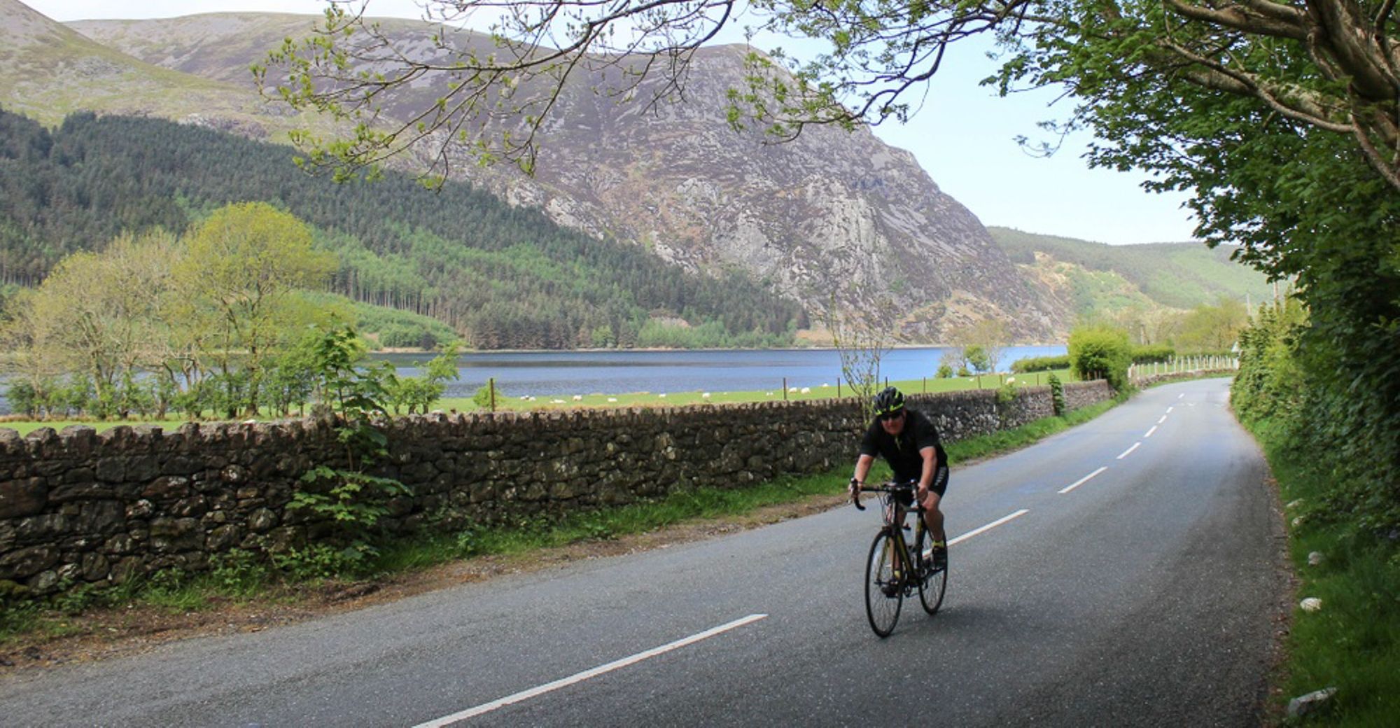 A cyclist on a rural road in Snowdonia national park