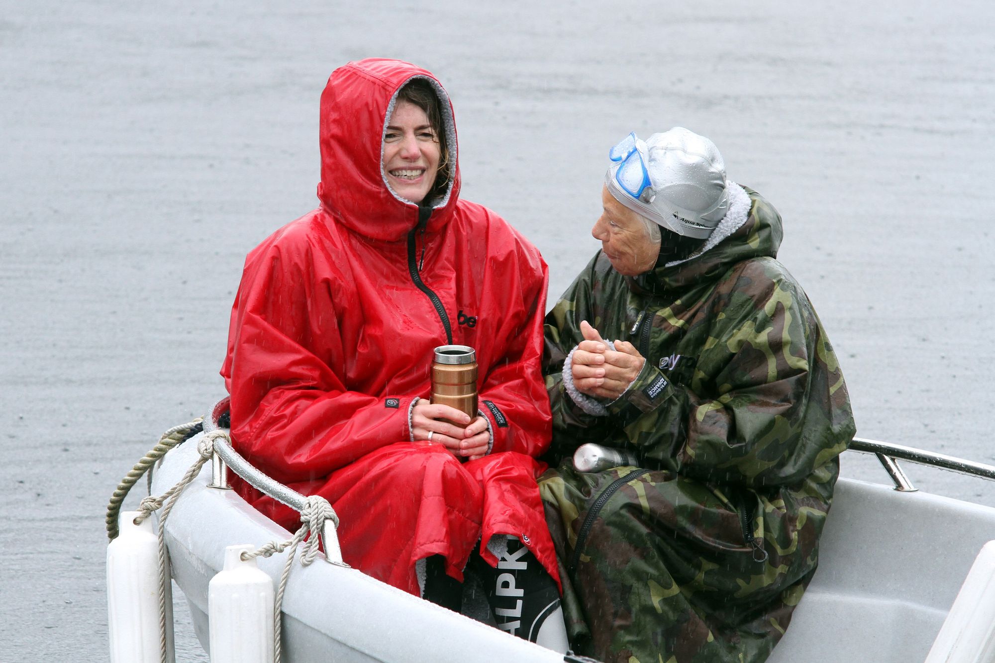 Two women warm up after an outdoor swim in the rain.