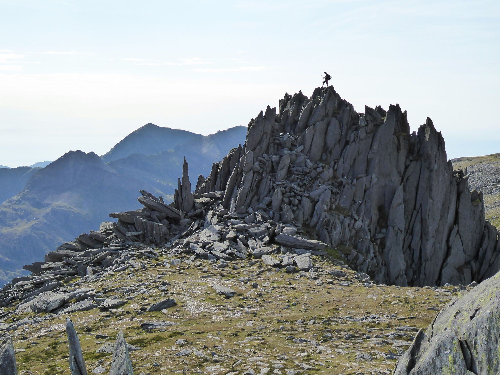 A hiker poses at the top of Glyder Fach summit, Snowdonia. Photo: Getty.