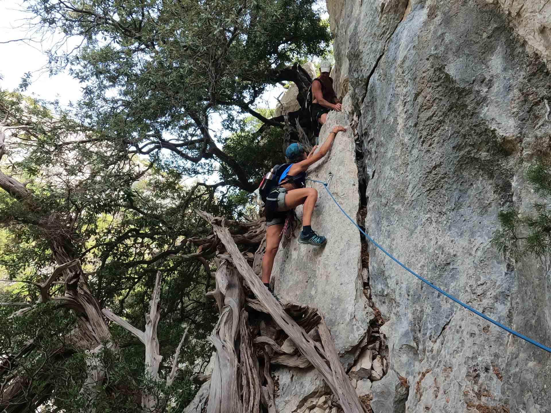 Climbers scrambling up a rock face on the Selvaggio Blu Trail