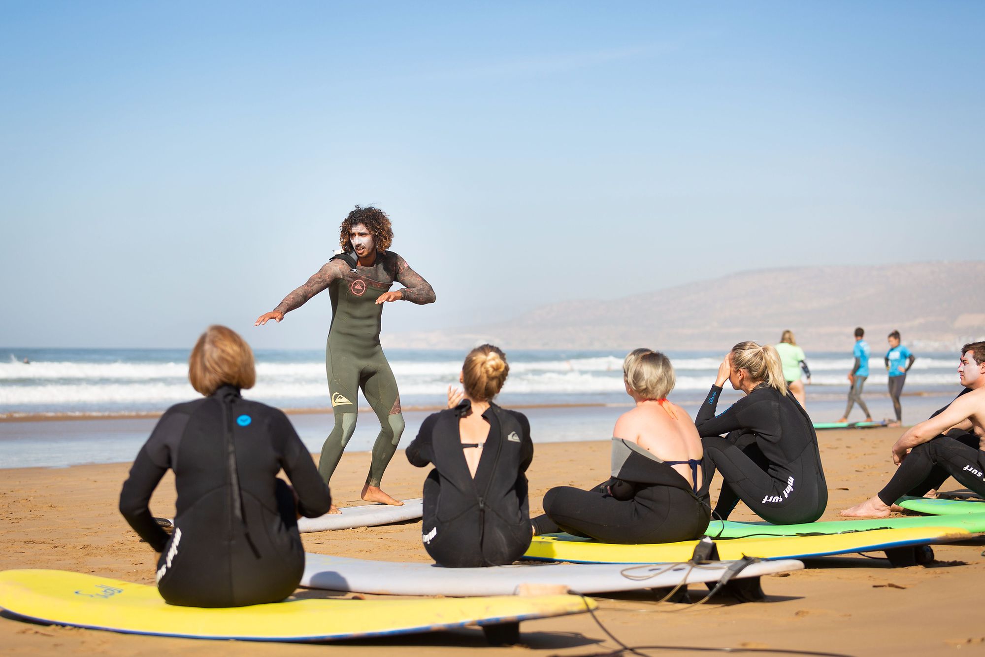 A surf instructor coaches a class on how to ride the waves of Morocco