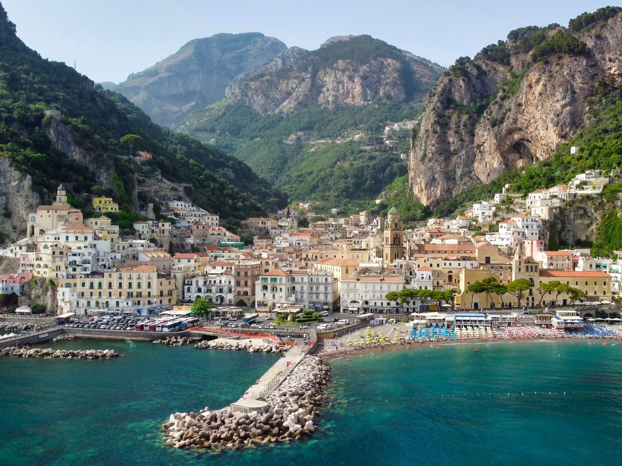 The Amalfi coastline, with beach loungers at the fore, and the colourful buildings layering into the mountains behind. Photo: Getty