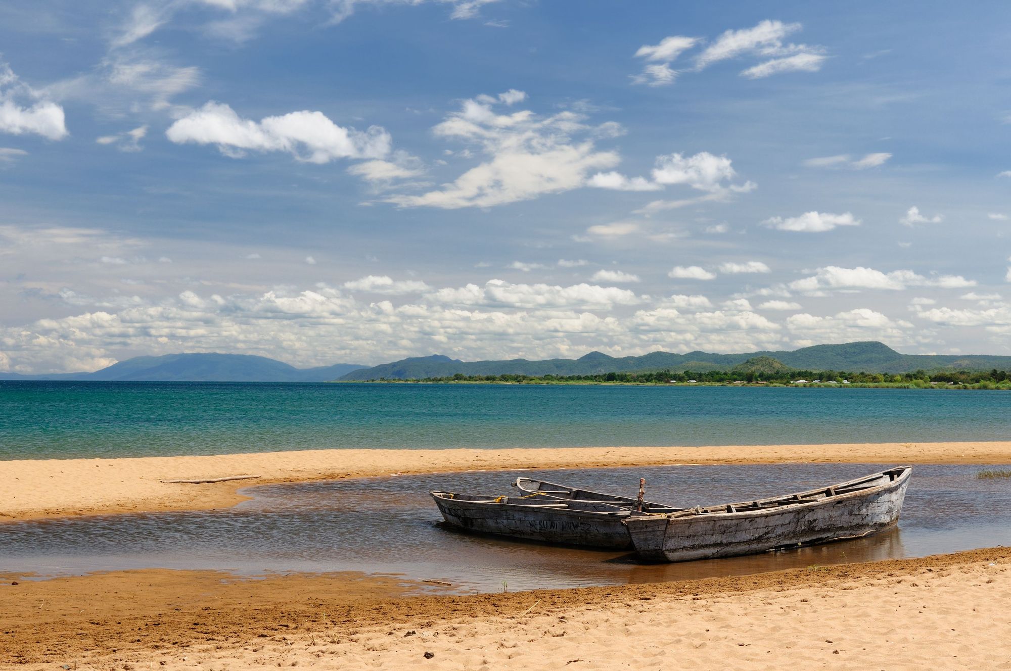 Three wooden boats tied up on the edge of Lake Tanganyika, one of Africa's Great Lakes. Photo: Getty
