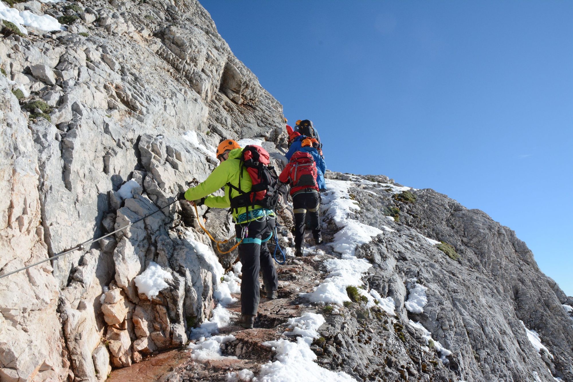 A group of hikers take on the via ferrata near the top of Mount Triglav