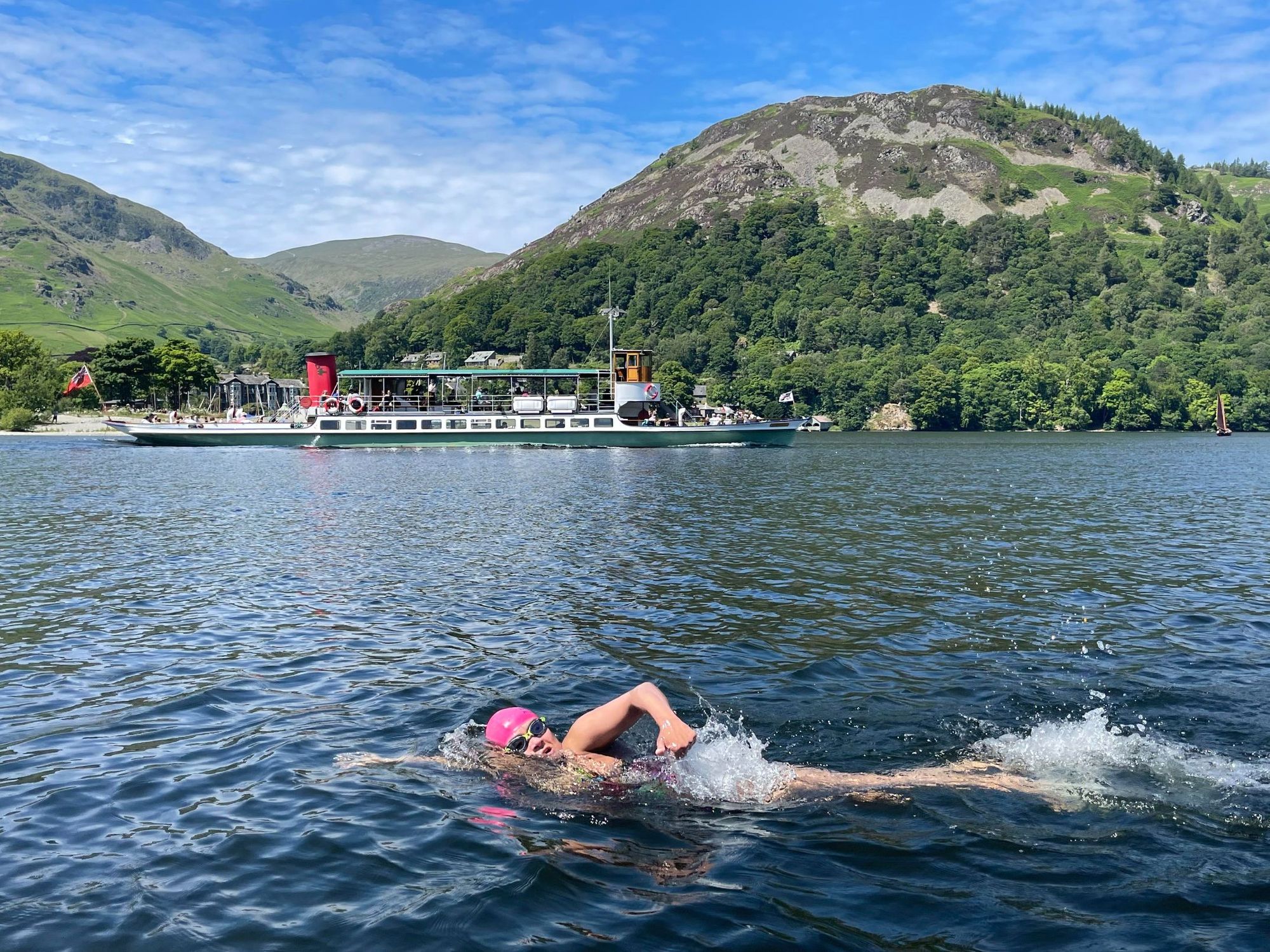 A woman swims across Ullswater, in the Lake District.