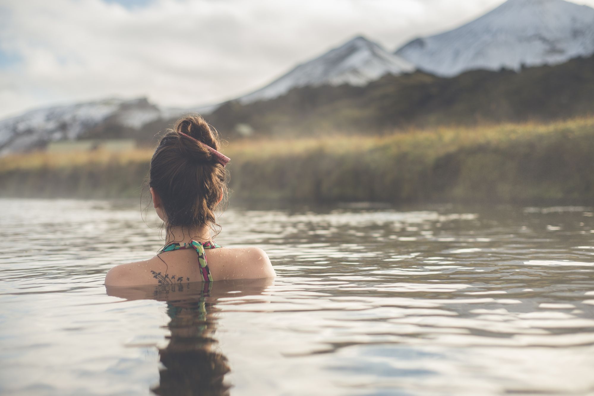 A woman dips in the Landmannalaugar hot springs, Iceland. Photo: Getty.