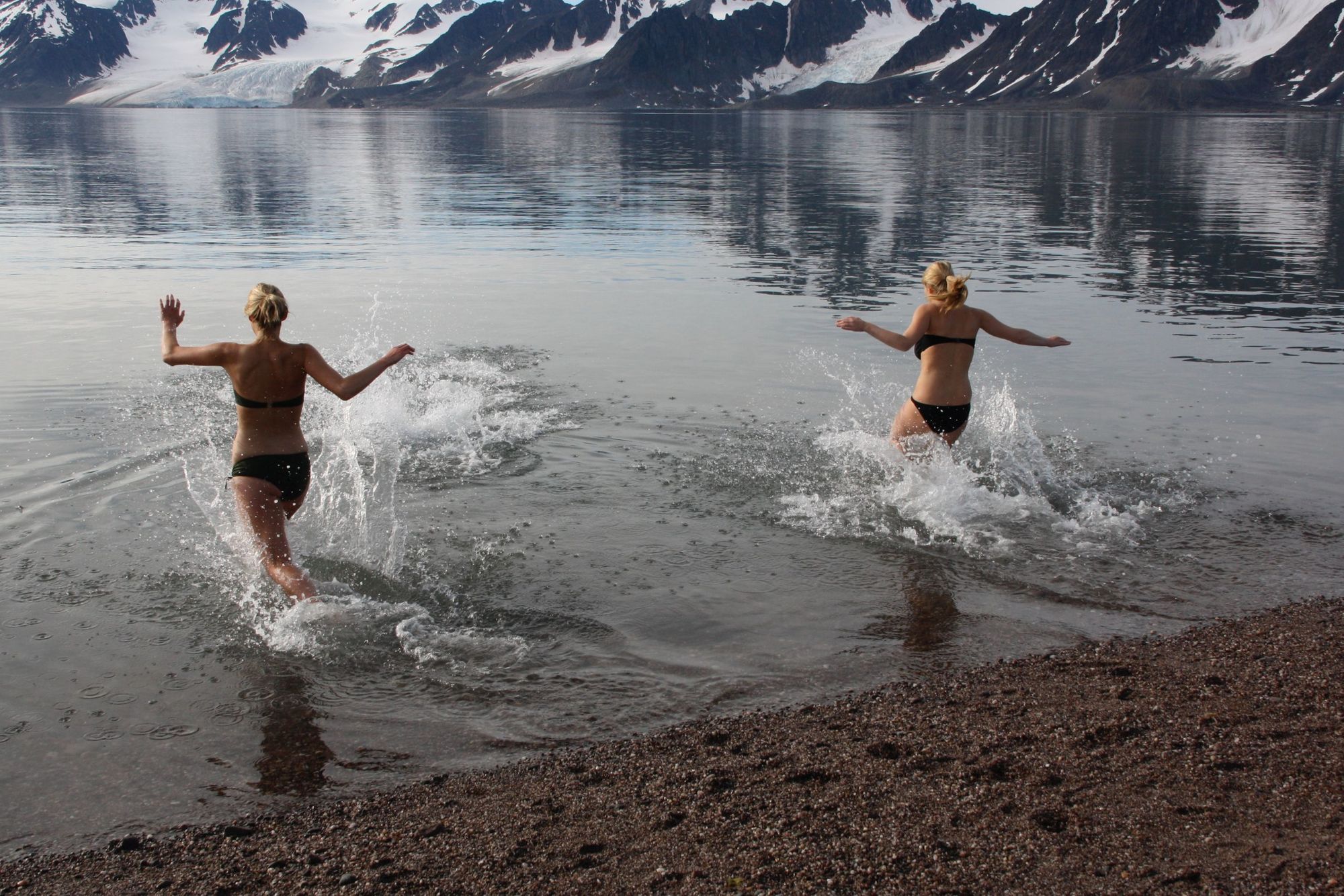Two women going for a swim in a fjord on Svalbard