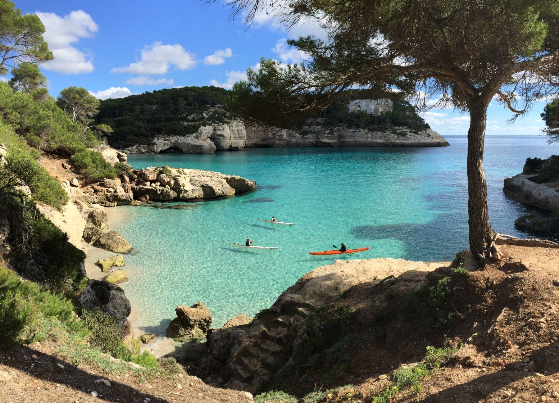 a group kayaking in a small bay in Menorca