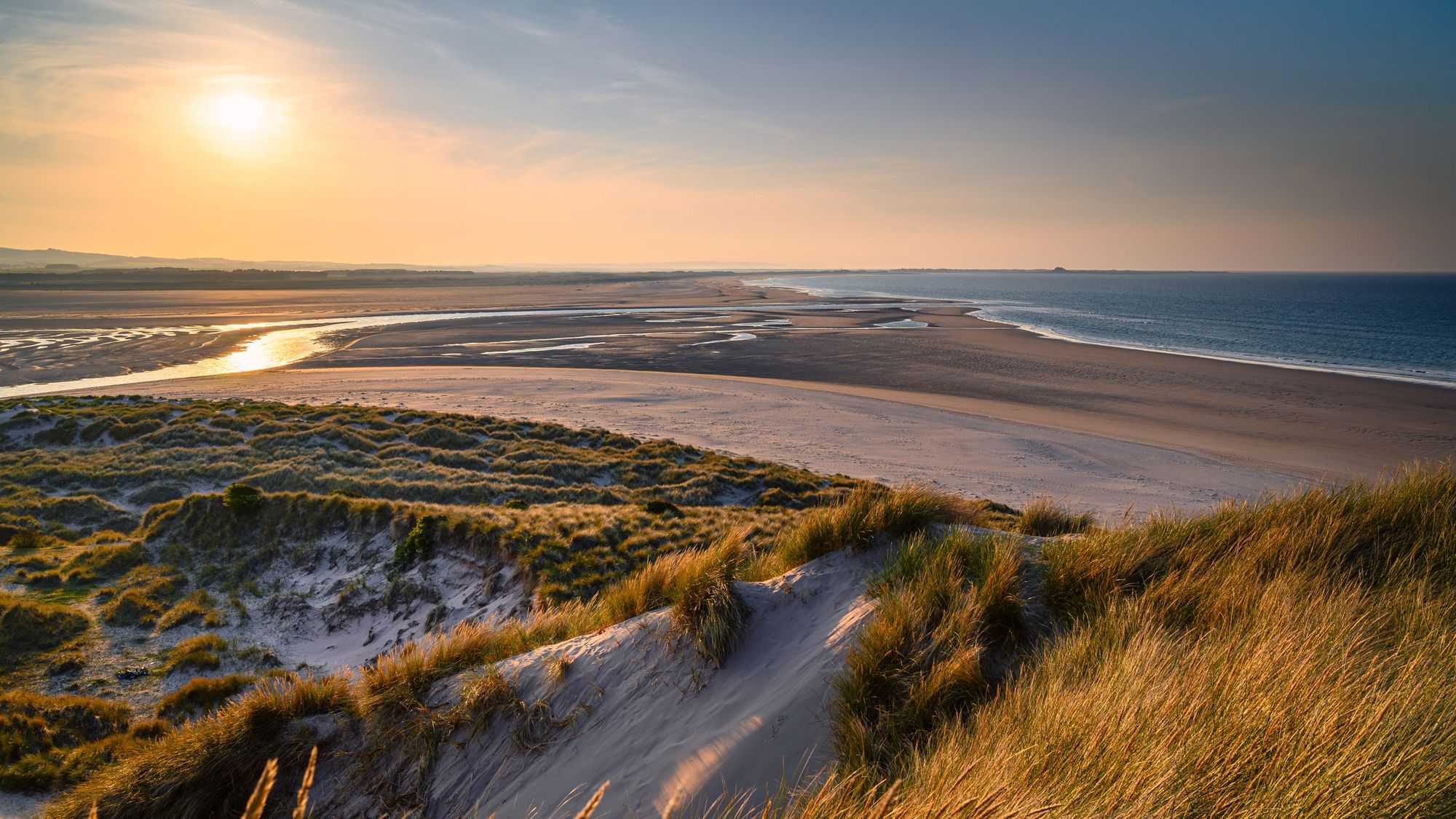 The mud flats at Budle Bay at low tide are part of Lindisfarne Nature reserve on Northumberland's AONB coastline. Photo: Getty