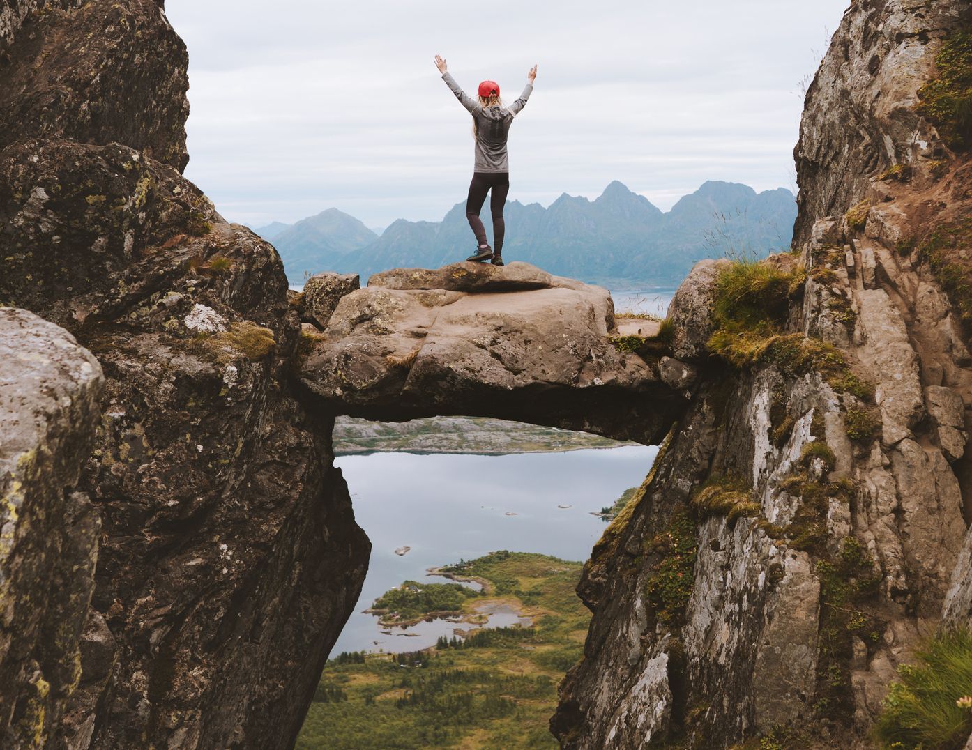 Posing on the Djevelporten, a rock bridge on the Lofoten Islands. Photo: Getty.