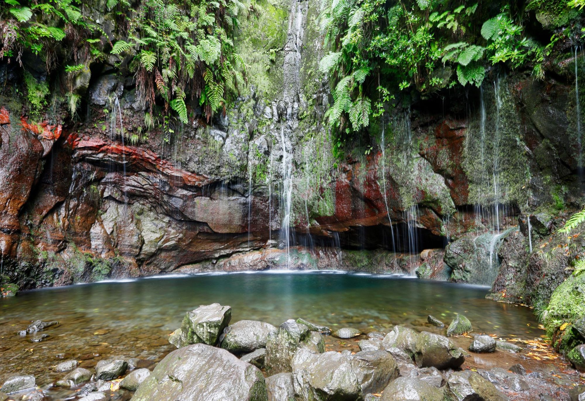 A waterfall on the 25 Fontes walk, which falls into this dreamy basin below. Photo: Getty
